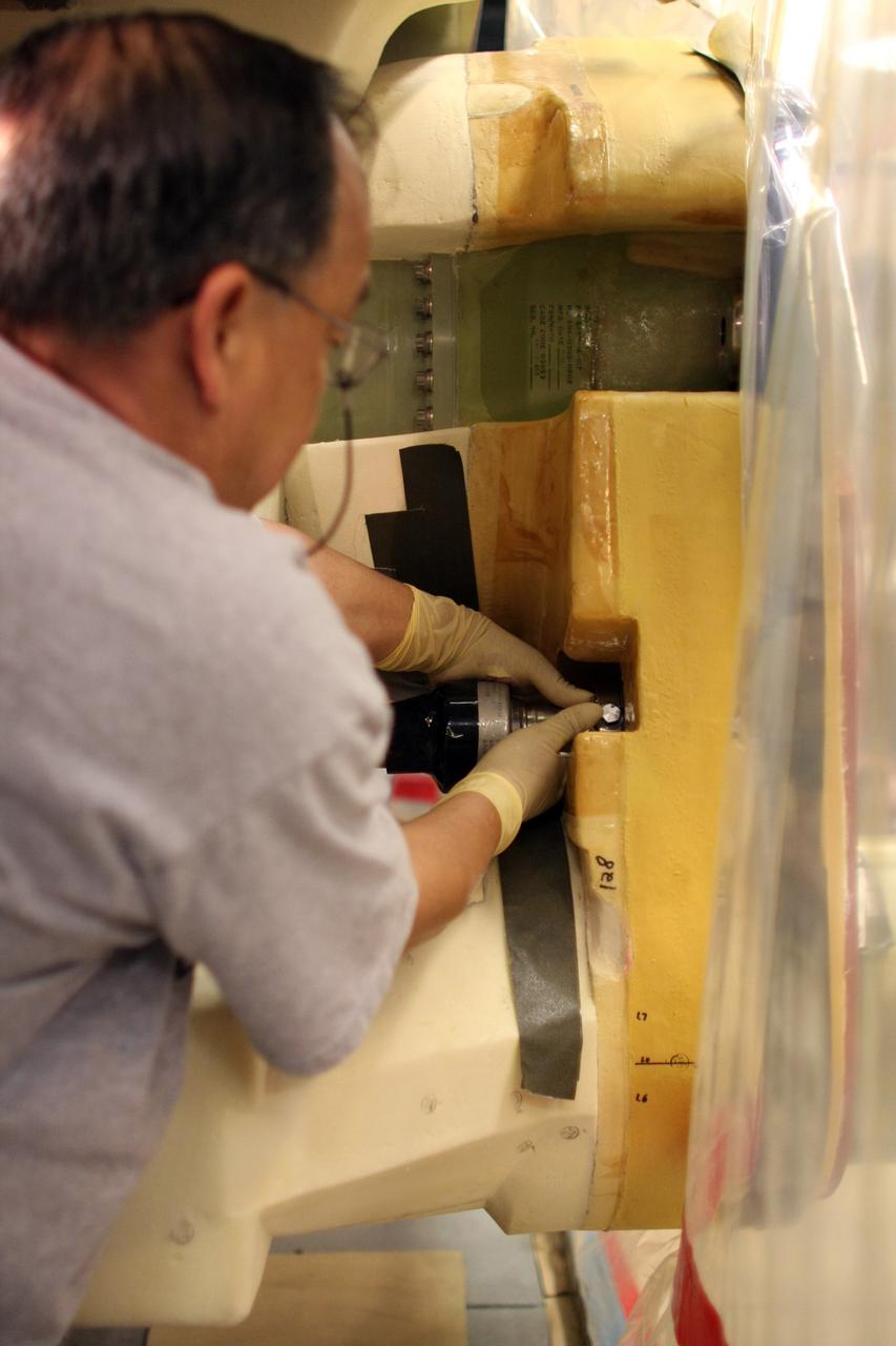 CAPE CANAVERAL, Fla. – Inside the Vehicle Assembly Building at NASA's Kennedy Space Center, a technician removes a valve on Atlantis’ external tank after small dings were found on the sealing surface of the quick disconnect system that handles liquid-hydrogen fuel for the shuttle’s three main engines. The tank will be attached to the twin solid rocket boosters on Aug. 3 for the STS-125 mission, the fifth and final shuttle servicing mission to NASA’s Hubble Space Telescope. During the mission, the crew will install new instruments on the telescope, including the Cosmic Origins Spectrograph and the Wide Field Camera 3. A refurbished Fine Guidance Sensor will replace one unit of three now onboard. Mission specialists will also install new gyroscopes, batteries and thermal blankets on the telescope. Launch is targeted for Oct. 8. Photo credit: NASA/Dimitri Gerondidakis