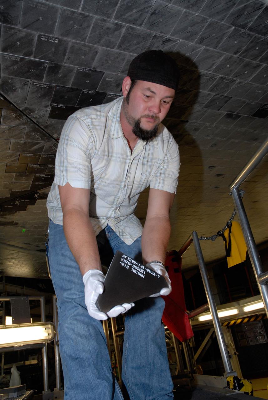 CAPE CANAVERAL, Fla. – Inside Orbiter Processing Facility 2 at NASA's Kennedy Space Center, a United Space Alliance technician holds one of the Boeing Replacement Insulation 18, or BRI-18, tile that will be installed on space shuttle Endeavour during processing activities. BRI-18 is the strongest material used for thermal insulation on the orbiters and, when coated to produce toughened unipiece fibrous insulation, provides a tile with extremely high-impact resistance. It is replacing other tiles on areas of the vehicle where impact risk is high, such as the landing gear doors, the wing leading edge and the external tank doors. Endeavour will deliver a multi-purpose logistics module to the International Space Station on its STS-126 mission. Launch is targeted for Nov. 10.  Photo credit: NASA/Jack Pfaller