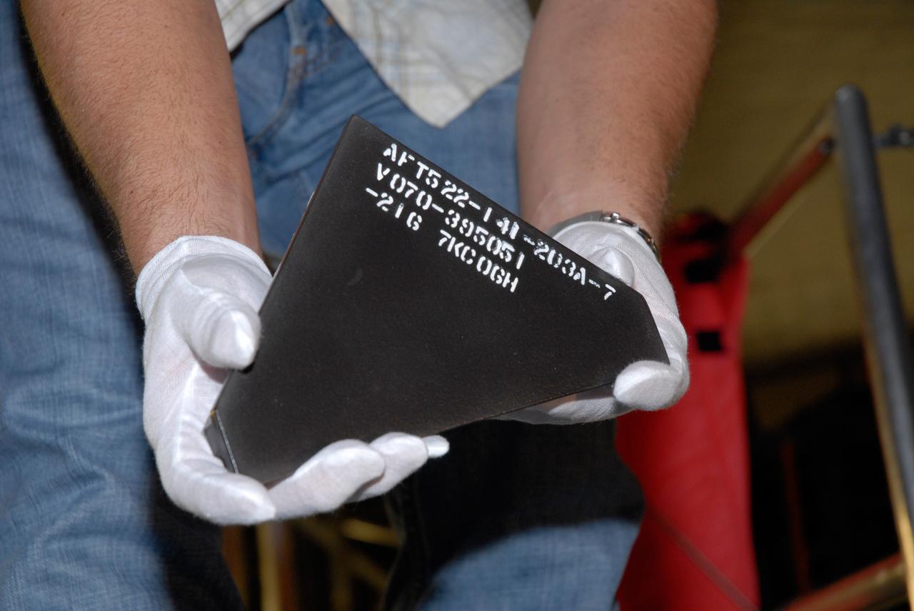 CAPE CANAVERAL, Fla. – Inside Orbiter Processing Facility 2 at NASA's Kennedy Space Center, a United Space Alliance technician holds one of the Boeing Replacement Insulation 18, or BRI-18, tile that will be installed on space shuttle Endeavour during processing activities. BRI-18 is the strongest material used for thermal insulation on the orbiters and, when coated to produce toughened unipiece fibrous insulation, provides a tile with extremely high-impact resistance. It is replacing other tiles on areas of the vehicle where impact risk is high, such as the landing gear doors, the wing leading edge and the external tank doors. Endeavour will deliver a multi-purpose logistics module to the International Space Station on its STS-126 mission. Launch is targeted for Nov. 10.  Photo credit: NASA/Jack Pfaller