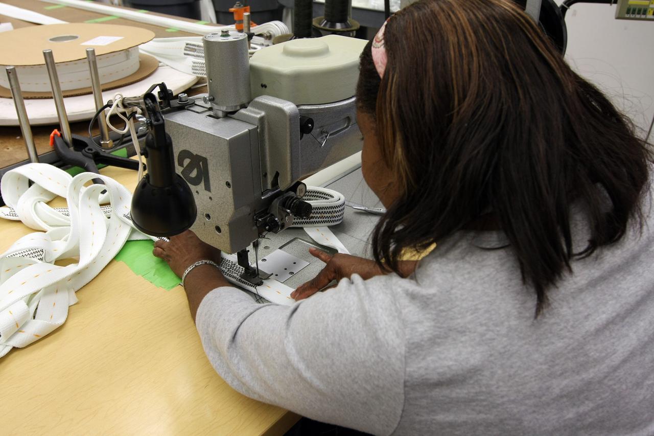 CAPE CANAVERAL, Fla. – Parachute technician Betty Smith sews Ares-I parachute suspension lines in the Parachute Refurbishment Facility at NASA's Kennedy Space Center. Ares I is an in-line, two-stage rocket that will transport the Orion crew exploration vehicle to low-Earth orbit. The Ares I first stage will be a five-segment solid rocket booster based on the four-segment design used for the shuttle. As with the shuttle, this booster will fall away when spent, lowered by parachute into the Atlantic Ocean where it can be retrieved for re-use. Photo credit: NASA/Dimitri Gerondidakis