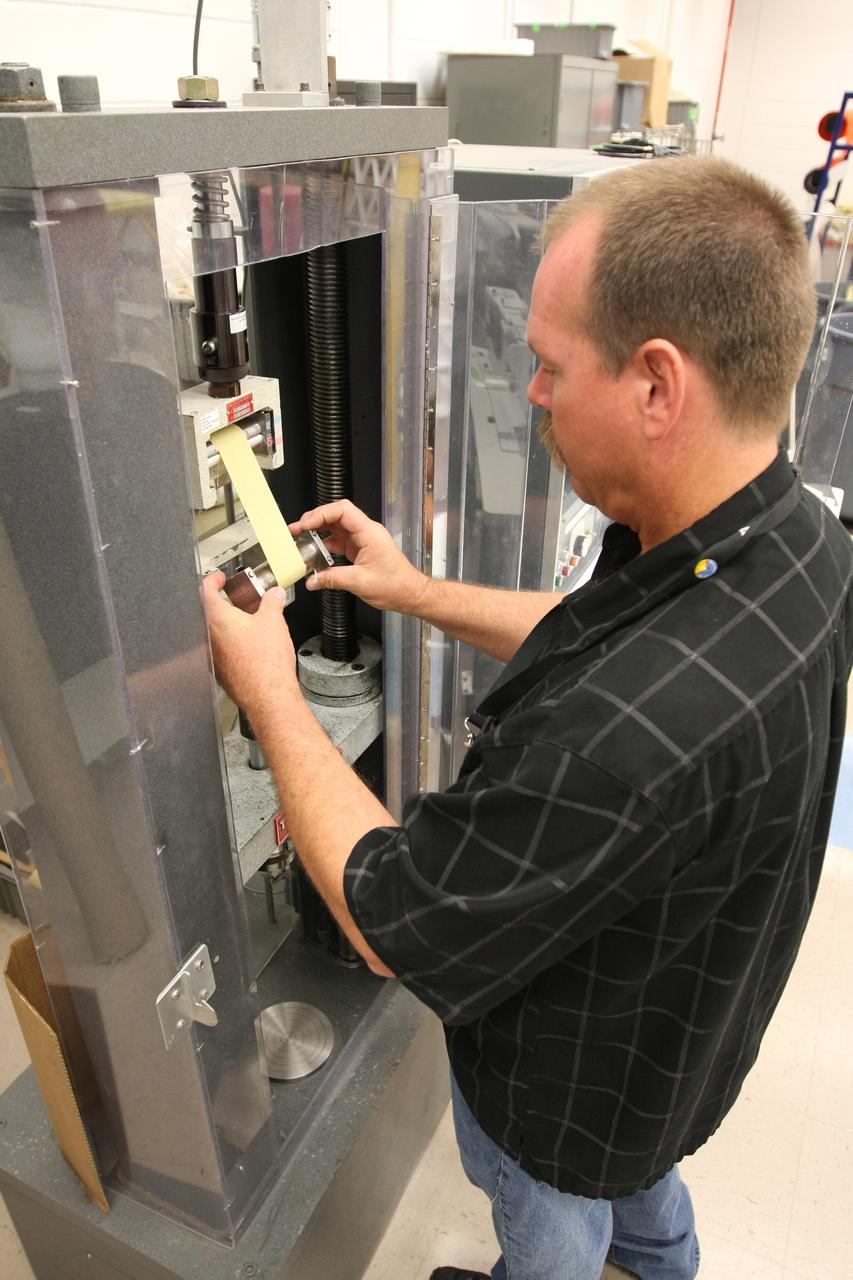 CAPE CANAVERAL, Fla. –  In the Parachute Refurbishment Facility at NASA's Kennedy Space Center, Dave Hillebrandt checks strapping equipment used on Ares-I parachutes.  Ares I is an in-line, two-stage rocket that will transport the Orion crew exploration vehicle to low-Earth orbit. The Ares I first stage will be a five-segment solid rocket booster based on the four-segment design used for the shuttle. As with the shuttle, this booster will fall away when spent, lowered by parachute into the Atlantic Ocean where it can be retrieved for re-use. Photo credit: NASA/Dimitri Gerondidakis