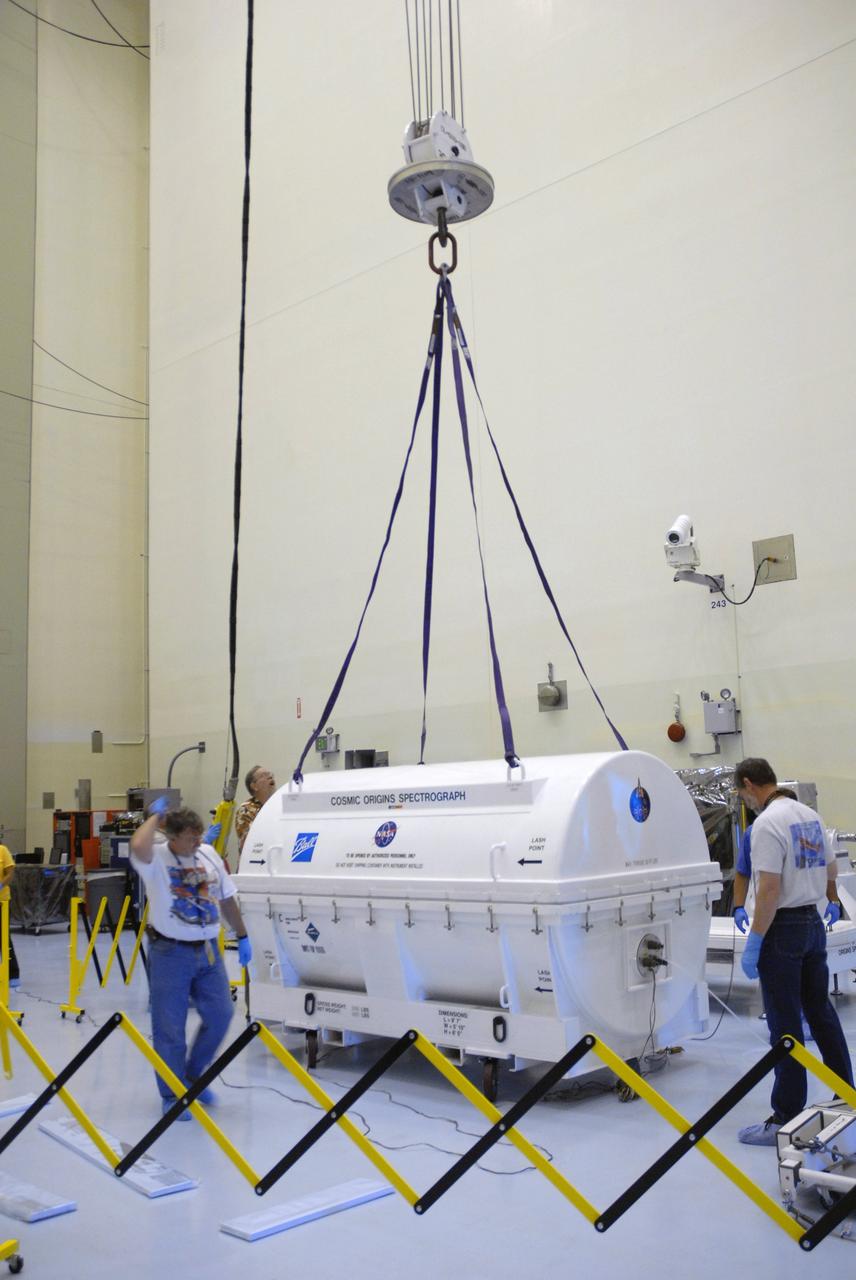 CAPE CANAVERAL, Fla. – At NASA's Kennedy Space Center, workers from NASA's Goddard Space Flight Center receive the Cosmic Origins Spectrograph, or COS, secured in its transportation canister, in the airlock of the Payload Hazardous Servicing Facility. The COS will be installed on the Hubble Space Telescope on space shuttle Atlantis' STS-125 mission.  COS will be the most sensitive ultraviolet spectrograph ever flown on Hubble and will probe the "cosmic web" - the large-scale structure of the universe whose form is determined by the gravity of dark matter and is traced by galaxies and intergalactic gas.  COS's far-ultraviolet channel has a sensitivity 30 times greater than that of previous spectroscopic instruments for the detection of extremely low light levels.  Launch of STS-125 is targeted for Oct. 8.  Photo credit: NASA/Jack Pfaller