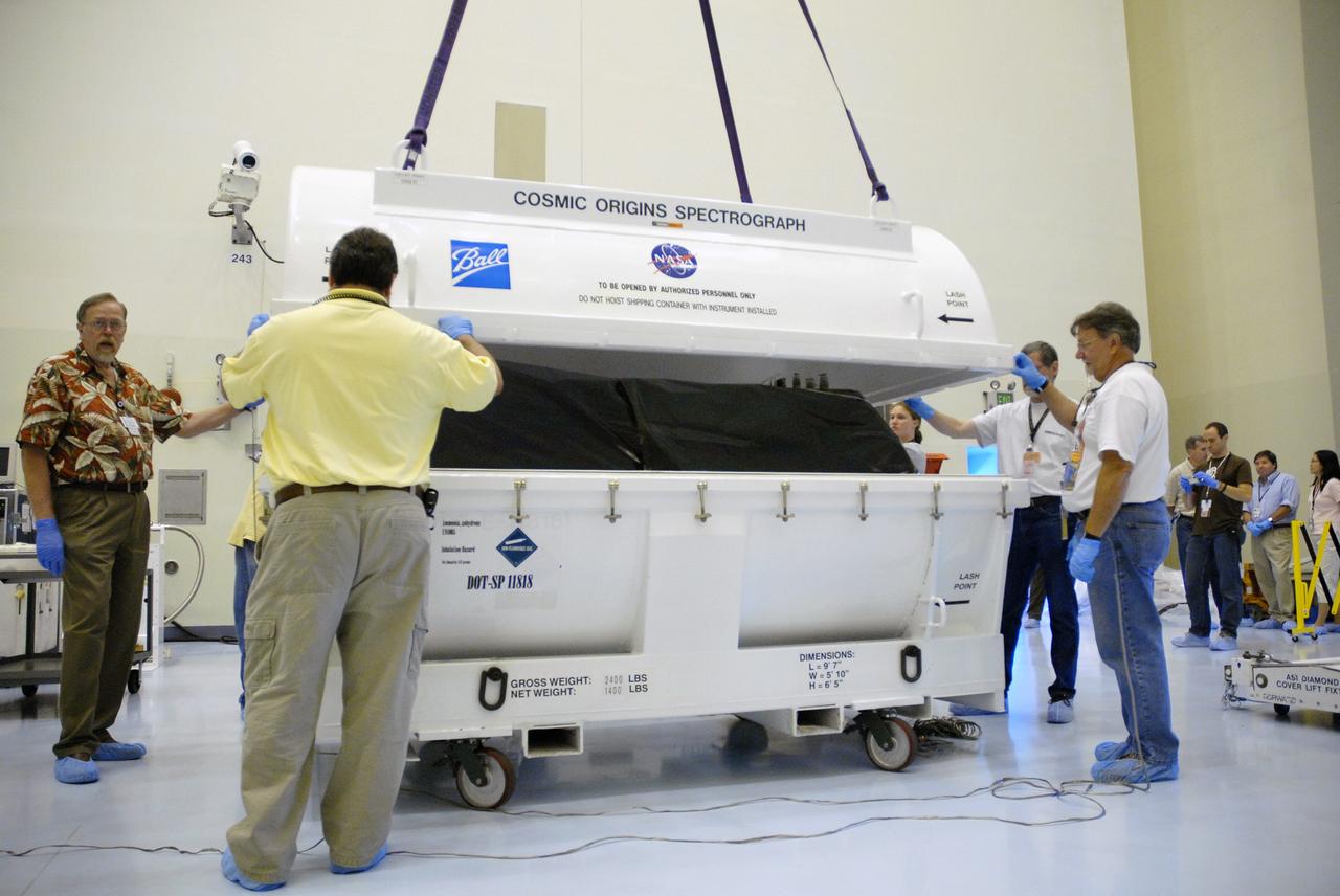 CAPE CANAVERAL, Fla. – In the airlock of the Payload Hazardous Servicing Facility at NASA's Kennedy Space Center, workers from NASA's Goddard Space Flight Center open the transportation canister in which the Cosmic Origins Spectrograph, or COS, is protected. The COS will be installed on the Hubble Space Telescope on space shuttle Atlantis' STS-125 mission.  COS will be the most sensitive ultraviolet spectrograph ever flown on Hubble and will probe the "cosmic web" - the large-scale structure of the universe whose form is determined by the gravity of dark matter and is traced by galaxies and intergalactic gas.  COS's far-ultraviolet channel has a sensitivity 30 times greater than that of previous spectroscopic instruments for the detection of extremely low light levels.  Launch of STS-125 is targeted for Oct. 8.  Photo credit: NASA/Jack Pfaller