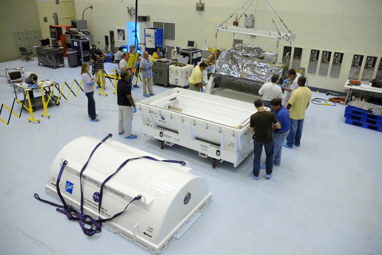 CAPE CANAVERAL, Fla. – In the airlock of the Payload Hazardous Servicing Facility at NASA's Kennedy Space Center, workers from NASA's Goddard Space Flight Center lower the Cosmic Origins Spectrograph, or COS, onto a dolly for its move into the clean room. The COS will be installed on the Hubble Space Telescope on space shuttle Atlantis' STS-125 mission.  COS will be the most sensitive ultraviolet spectrograph ever flown on Hubble and will probe the "cosmic web" - the large-scale structure of the universe whose form is determined by the gravity of dark matter and is traced by galaxies and intergalactic gas.  COS's far-ultraviolet channel has a sensitivity 30 times greater than that of previous spectroscopic instruments for the detection of extremely low light levels.  Launch of STS-125 is targeted for Oct. 8.  Photo credit: NASA/Jack Pfaller