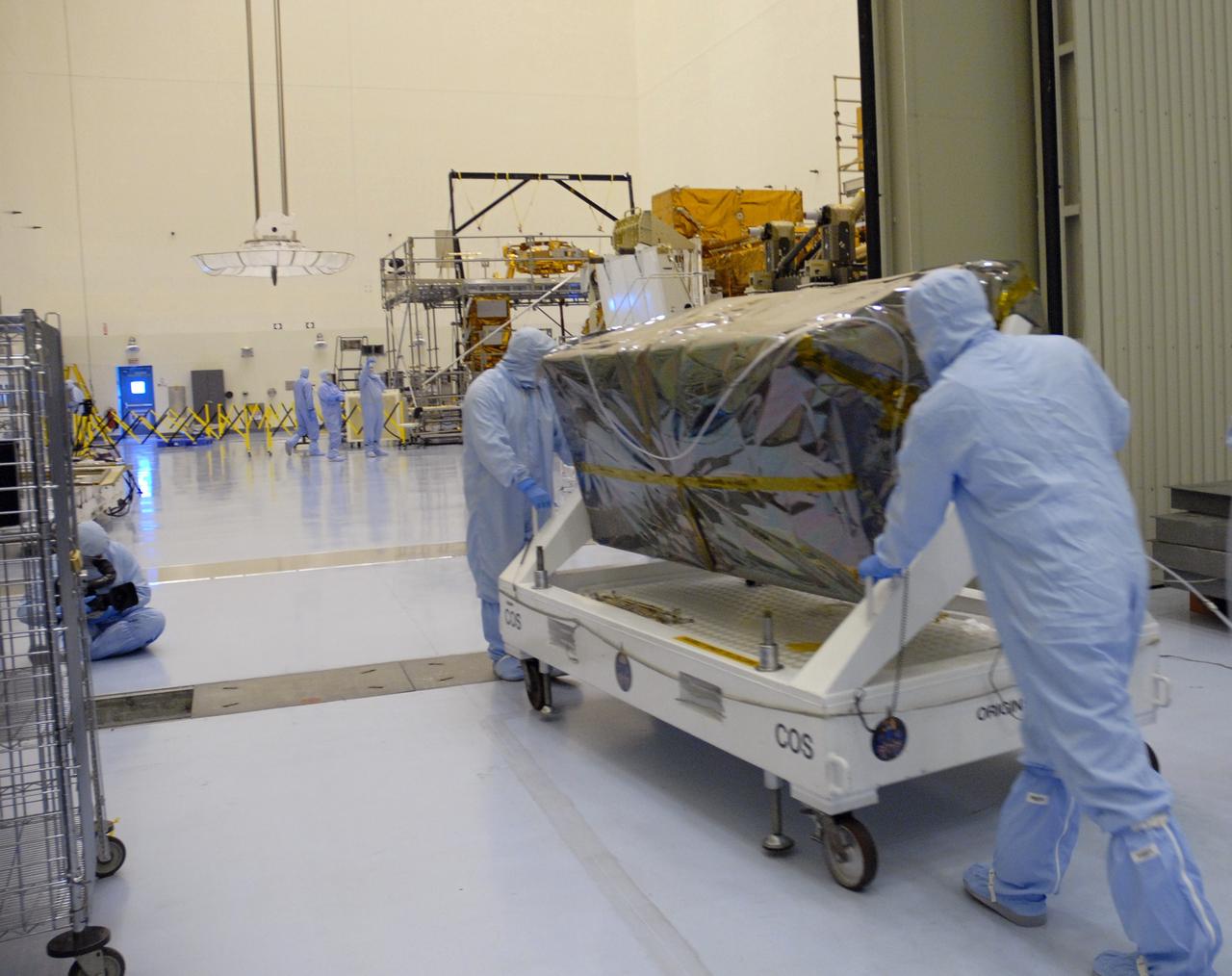 CAPE CANAVERAL, Fla. – At NASA's Kennedy Space Center, workers from NASA's Goddard Space Flight Center roll the Cosmic Origins Spectrograph, or COS, into the clean room of the Payload Hazardous Servicing Facility. The COS will be installed on the Hubble Space Telescope on space shuttle Atlantis' STS-125 mission.  COS will be the most sensitive ultraviolet spectrograph ever flown on Hubble and will probe the "cosmic web" - the large-scale structure of the universe whose form is determined by the gravity of dark matter and is traced by galaxies and intergalactic gas.  COS's far-ultraviolet channel has a sensitivity 30 times greater than that of previous spectroscopic instruments for the detection of extremely low light levels.  Launch of STS-125 is targeted for Oct. 8.  Photo credit: NASA/Jack Pfaller