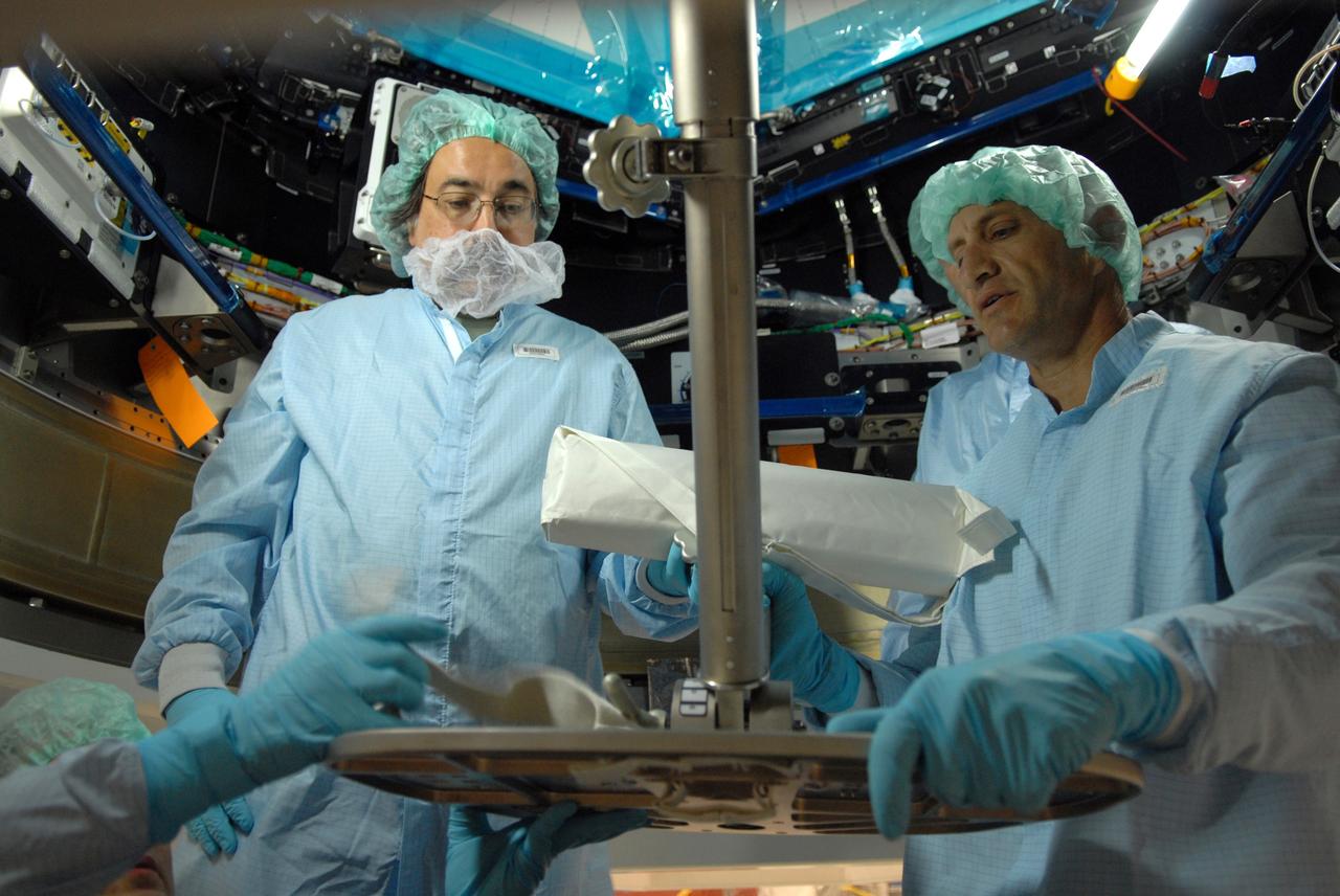 CAPE CANAVERAL, Fla. – In the Space Station Processing Facility at NASA's Kennedy Space Center, astronaut Charles Hobaugh, right, conducts a fit check of the robotic workstation, or RWS, in the International Space Station's Cupola module.  He is assisted by Boeing technician Terry Camarata, left. The RWS is provided by the Canadian Space Agency.  The module was delivered by the European Space Agency in 2004 to Kennedy from Alenia Spazio in Turin, Italy.  Cupola will provide unprecedented views of activities outside the station and spectacular views of the Earth.  Crew members working inside the module will have a 360-degree panoramic view.  Cupola has the capability for command and control workstations to be installed to assist in space station remote manipulator system and extra vehicular activities.  Cupola is the final element of the space station core and is scheduled for launch on space shuttle Endeavour's STS-130 mission, targeted for Dec. 10, 2009.  Photo credit: NASA/Cory Huston