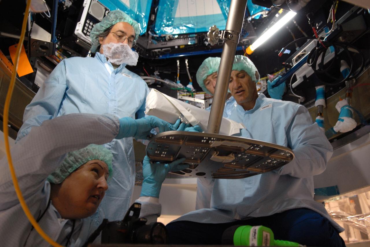 CAPE CANAVERAL, Fla. – In the Space Station Processing Facility at NASA's Kennedy Space Center, astronaut Charles Hobaugh, right, conducts a fit check of the robotic workstation, or RWS, in the International Space Station's Cupola module.  He is assisted by vehicle integration test engineer Louise Kleba of Flight Crew Operations, kneeling, Boeing technician Terry Camarata, standing at left, and engineer David Jackson, from Johnson Space Center. The RWS is provided by the Canadian Space Agency.  The module was delivered by the European Space Agency in 2004 to Kennedy from Alenia Spazio in Turin, Italy.  Cupola will provide unprecedented views of activities outside the station and spectacular views of the Earth.  Crew members working inside the module will have a 360-degree panoramic view.  Cupola has the capability for command and control workstations to be installed to assist in space station remote manipulator system and extra vehicular activities.  Cupola is the final element of the space station core and is scheduled for launch on space shuttle Endeavour's STS-130 mission, targeted for Dec. 10, 2009.  Photo credit: NASA/Cory Huston