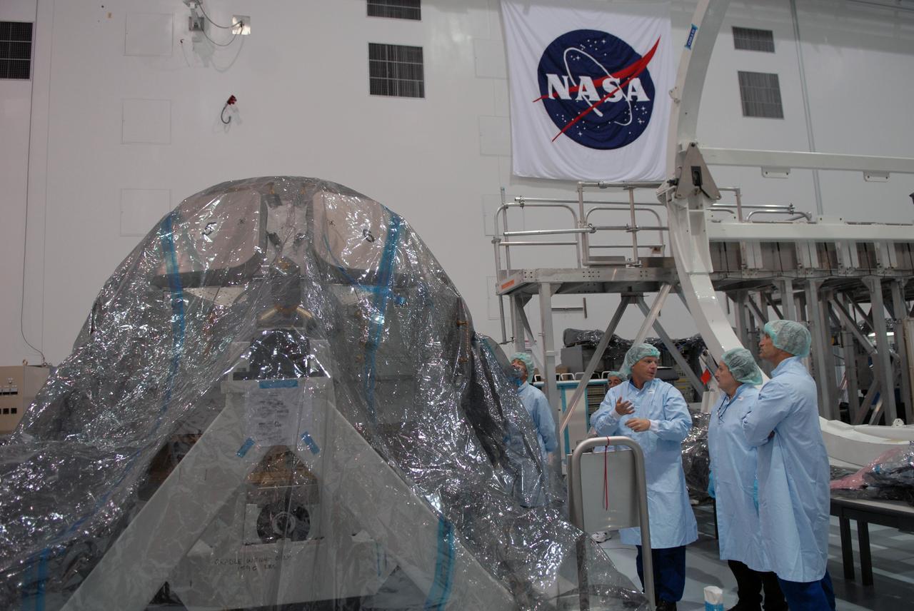 CAPE CANAVERAL, Fla. – In the Space Station Processing Facility at NASA's Kennedy Space Center, astronaut Terry Virts, third from left, discusses the intricacies of the International Space Station's Cupola module with vehicle integration test engineer Louise Kleba of Flight Crew Operations and astronaut Charles Hobaugh, right. The module was delivered by the European Space Agency in 2004 to Kennedy from Alenia Spazio in Turin, Italy.  Cupola will provide unprecedented views of activities outside the station and spectacular views of the Earth.  Crew members working inside the module will have a 360-degree panoramic view.  Cupola has the capability for command and control workstations to be installed to assist in space station remote manipulator system and extra vehicular activities.  Cupola is the final element of the space station core and is scheduled for launch on space shuttle Endeavour's STS-130 mission, targeted for Dec. 10, 2009.  Photo credit: NASA/Cory Huston