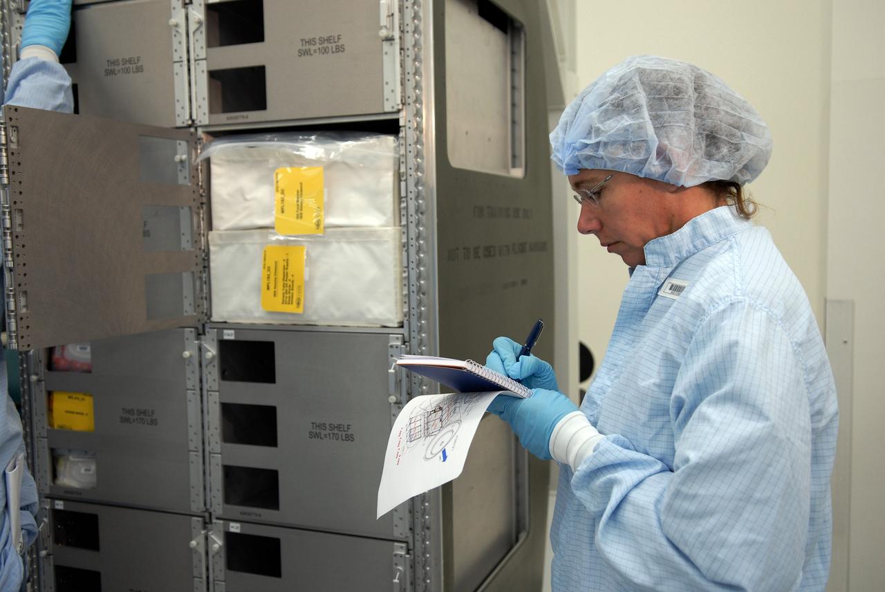 CAPE CANAVERAL, Fla. – In the Space Station Processing Facility at NASA's Kennedy Space Center, members of space shuttle Endeavour's STS-126 crew participate in a crew equipment interface test, or CEIT.  Here, Mission Specialist Sandra Magnus makes notes regarding a piece of hardware on a stowage rack. The CEIT provides hands-on experience with hardware and equipment slated to fly on their mission.  Endeavour will deliver a multi-purpose logistics module to the International Space Station on the STS-126 mission. Launch is targeted for Nov. 10.  Photo credit: NASA/Kim Shiflett