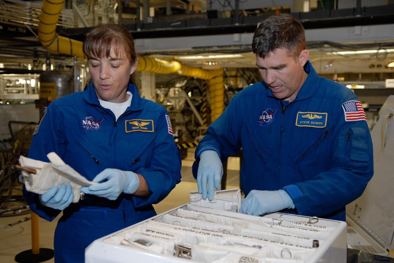 CAPE CANAVERAL, Fla. –  In Orbiter Processing Facility 2 at NASA's Kennedy Space Center, STS-126 Mission Specialists Heidemarie Stefanyshyn-Piper and Steve Bowen look over tools required for the mission. Members of space shuttle Endeavour's STS-126 crew are at Kennedy to participate in a crew equipment interface test, or CEIT.  The CEIT provides experience handling tools, equipment and hardware they will use on the mission. Endeavour will deliver a multi-purpose logistics module to the International Space Station on the STS-126 mission. Launch is targeted for Nov. 10.  Photo credit: NASA/Kim Shiflett