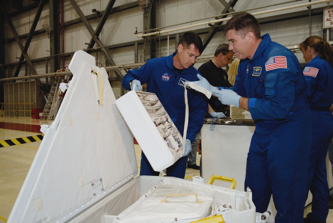 CAPE CANAVERAL, Fla. –  In Orbiter Processing Facility 2 at NASA's Kennedy Space Center, STS-126 Mission Specialists Shane Kimbrough (left), Steve Bowen (center) and Heidemarie Stefanyshyn-Piper (right) look over tools required for the mission.   Members of space shuttle Endeavour's STS-126 crew are at Kennedy to participate in a crew equipment interface test, or CEIT.  The CEIT provides experience handling tools, equipment and hardware they will use on the mission. Endeavour will deliver a multi-purpose logistics module to the International Space Station on the STS-126 mission. Launch is targeted for Nov. 10.  Photo credit: NASA/Kim Shiflett
