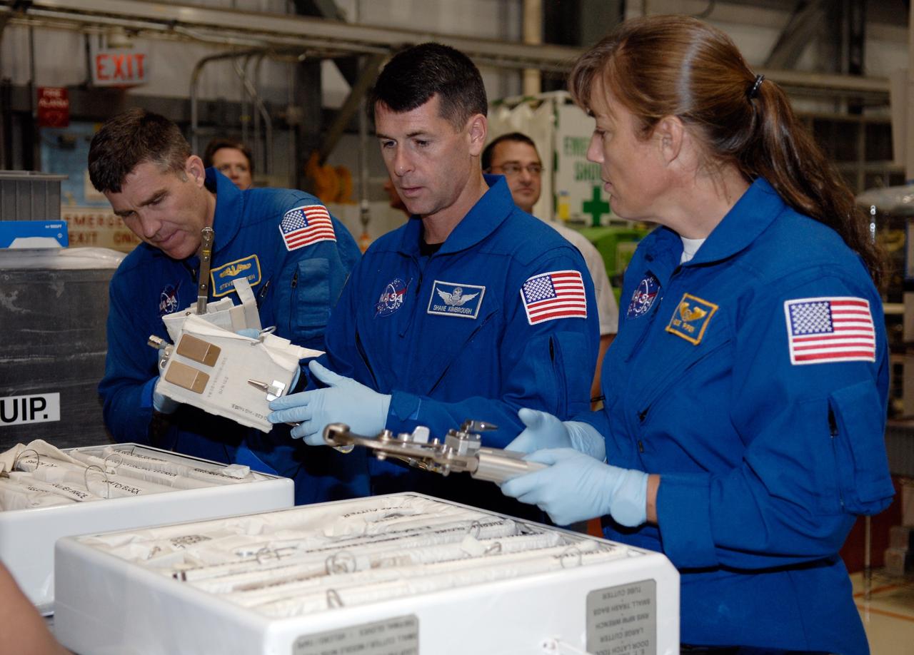CAPE CANAVERAL, Fla. –  In Orbiter Processing Facility 2 at NASA's Kennedy Space Center, STS-126 Mission Specialists (from left) Steve Bowen, Shane Kimbrough and Heidemarie Stefanyshyn-Piper handle tools required for the mission.  Members of space shuttle Endeavour's STS-126 crew are at Kennedy to participate in a crew equipment interface test, or CEIT.  The CEIT provides experience handling tools, equipment and hardware they will use on the mission. Endeavour will deliver a multi-purpose logistics module to the International Space Station on the STS-126 mission. Launch is targeted for Nov. 10.  Photo credit: NASA/Kim Shiflett