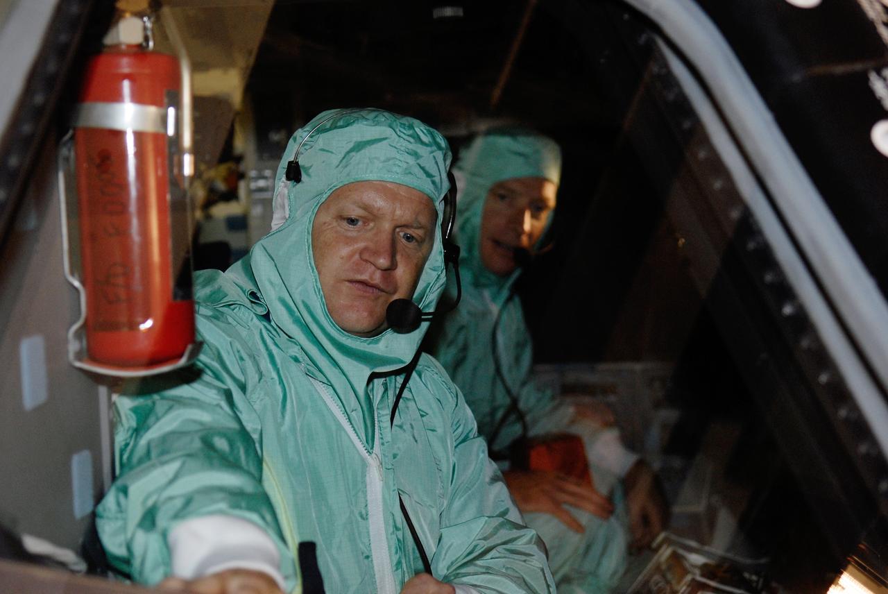 CAPE CANAVERAL, Fla. –  In Orbiter Processing Facility 2 at NASA's Kennedy Space Center, STS-126 Pilot Eric Boe inspects the cockpit window of space shuttle Endeavour.  Behind him is Commander Chris Ferguson.  Members of space shuttle Endeavour's STS-126 crew are at Kennedy to participate in a crew equipment interface test, or CEIT.  The CEIT provides experience handling tools, equipment and hardware they will use on the mission. Endeavour will deliver a multi-purpose logistics module to the International Space Station on the STS-126 mission. Launch is targeted for Nov. 10.  Photo credit: NASA/Kim Shiflett