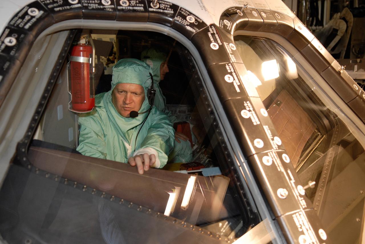 CAPE CANAVERAL, Fla. –  In Orbiter Processing Facility 2 at NASA's Kennedy Space Center, STS-126 Pilot Eric Boe inspects the cockpit window of space shuttle Endeavour.  Members of space shuttle Endeavour's STS-126 crew are at Kennedy to participate in a crew equipment interface test, or CEIT.  The CEIT provides experience handling tools, equipment and hardware they will use on the mission. Endeavour will deliver a multi-purpose logistics module to the International Space Station on the STS-126 mission. Launch is targeted for Nov. 10.  Photo credit: NASA/Kim Shiflett