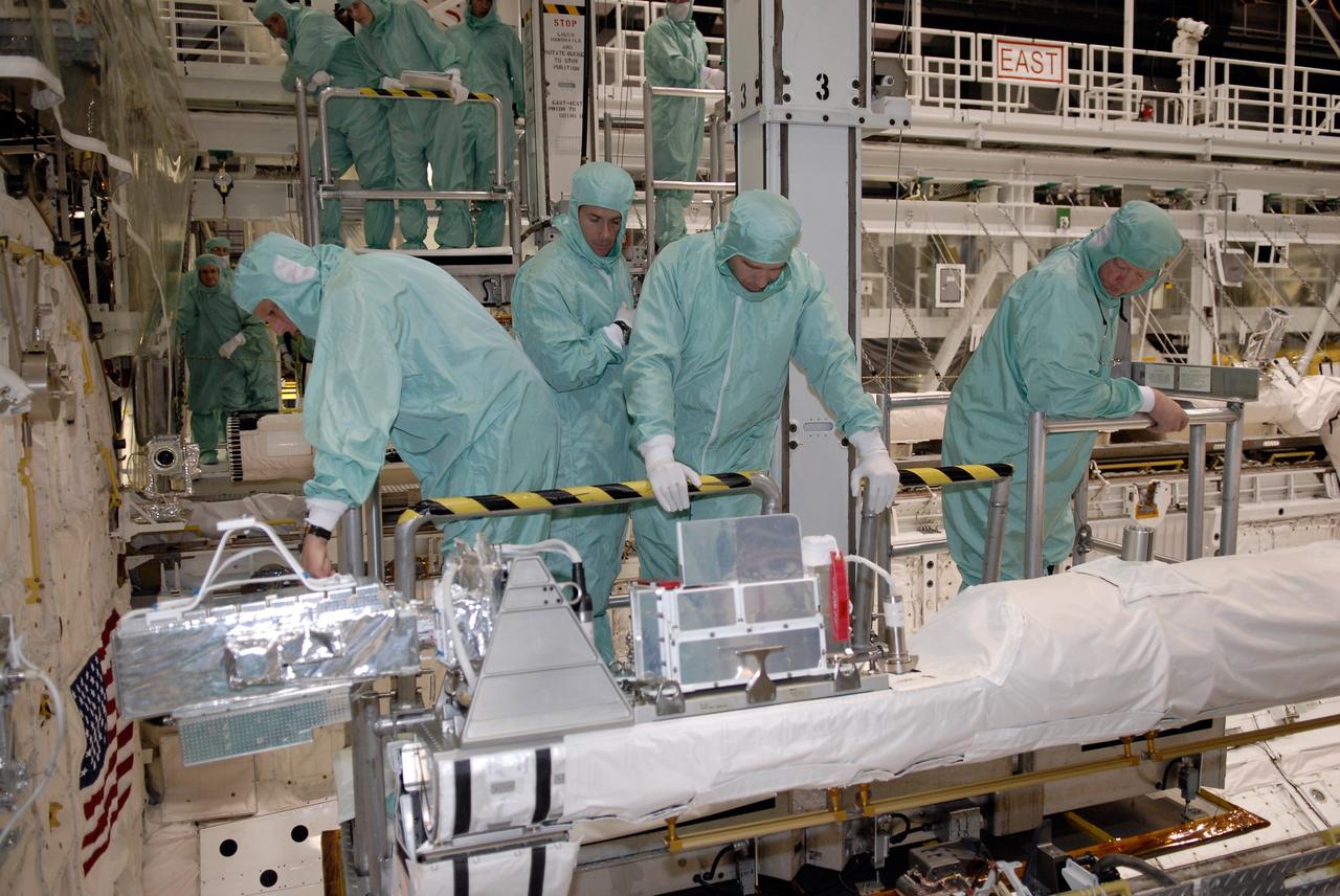 CAPE CANAVERAL, Fla. –  In Orbiter Processing Facility 2 at NASA's Kennedy Space Center, STS-126 Commander Chris Ferguson (left) and Mission Specialists Shane Kimbrough and Steve Bowen get a close look at hardware inside space shuttle Endeavour's payload bay. Members of space shuttle Endeavour's STS-126 crew are at Kennedy to participate in a crew equipment interface test, or CEIT.  The CEIT provides experience handling tools, equipment and hardware they will use on the mission. Endeavour will deliver a multi-purpose logistics module to the International Space Station on the STS-126 mission. Launch is targeted for Nov. 10.  Photo credit: NASA/Kim Shiflett