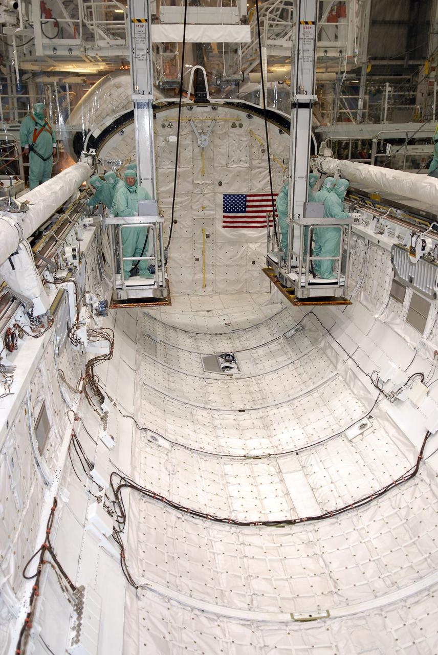 CAPE CANAVERAL, Fla. –  In Orbiter Processing Facility 2 at NASA's Kennedy Space Center, STS-126 crew members are lowered inside space shuttle Endeavour's payload bay to inspect hardware like the shuttle's robotic arm and orbiter boom sensor system.  Members of space shuttle Endeavour's STS-126 crew are at Kennedy to participate in a crew equipment interface test, or CEIT.  The CEIT provides experience handling tools, equipment and hardware they will use on the mission. Endeavour will deliver a multi-purpose logistics module to the International Space Station on the STS-126 mission. Launch is targeted for Nov. 10.  Photo credit: NASA/Kim Shiflett