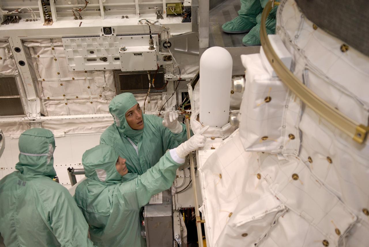 CAPE CANAVERAL, Fla. –  In Orbiter Processing Facility 2 at NASA's Kennedy Space Center, STS-126 Mission Specialist Heidemarie Stefanyshyn-Piper (top right) is shown part of the equipment stored in space shuttle Endeavour's payload bay.   Members of space shuttle Endeavour's STS-126 crew are at Kennedy to participate in a crew equipment interface test, or CEIT.  The CEIT provides experience handling tools, equipment and hardware they will use on the mission. Endeavour will deliver a multi-purpose logistics module to the International Space Station on the STS-126 mission. Launch is targeted for Nov. 10.  Photo credit: NASA/Kim Shiflett