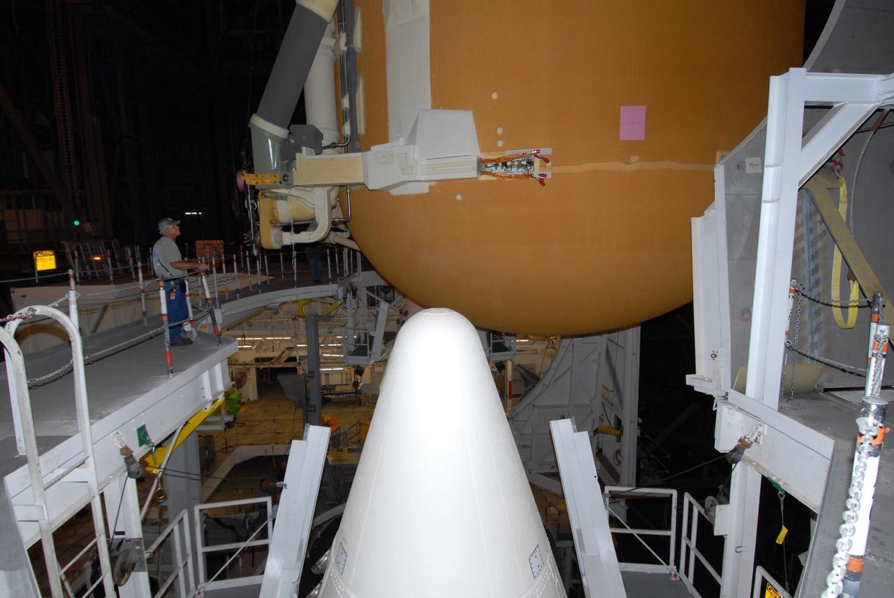 CAPE CANAVERAL, Fla. – In the Vehicle Assembly Building at NASA's Kennedy Space Center, the external tank for space shuttle Atlantis is lowered toward the solid rocket boosters (the nose cone of one of the boosters is seen here) for mating. The tank and boosters will be secured on the mobile launcher platform below.  Atlantis' STS-125 mission is the fifth and final shuttle servicing mission to NASA’s Hubble Space Telescope.  Launch is targeted for Oct. 8.    Photo credit: NASA/Jack Pfaller