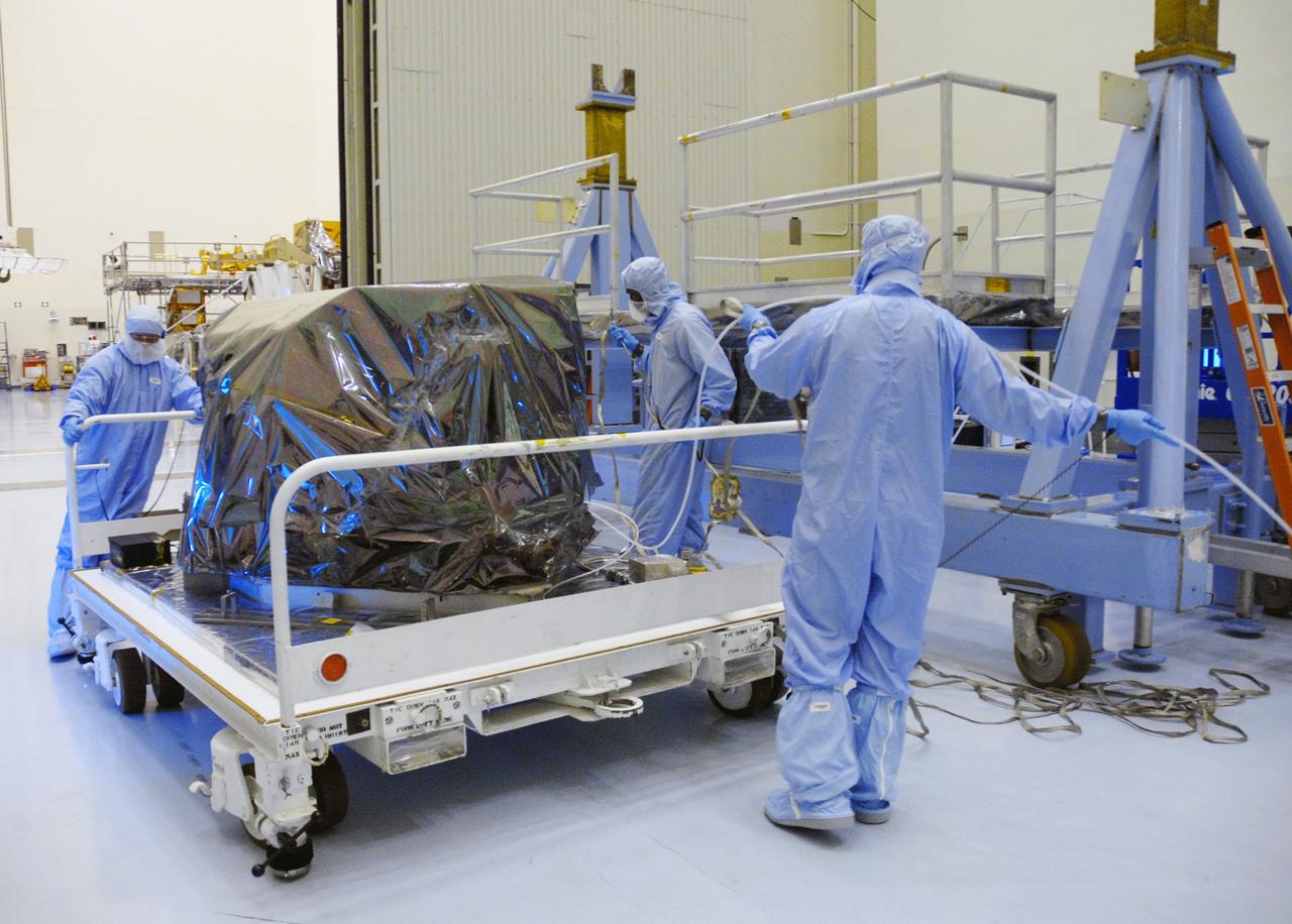 CAPE CANAVERAL, Fla. –  In the Payload Hazardous Servicing Facility at NASA's Kennedy Space Center, workers move the Hubble Fine Guidance Sensor, or FGS, before removing the protective cover.  The FGS will be integrated onto the Orbital Replacement Unit carrier in the clean room of the facility. The sensor will extend the life of the pointing control system on the Hubble Space Telescope. On the mission, this FGS will replace one of the three sensors that is failing and thus outfit the telescope with two completely healthy units, which are needed.  A third, older FGS aboard the telescope will provide additional target-pointing efficiency and redundancy.  Space shuttle Atlantis is targeted to launch on the STS-125 mission Oct. 8.   Photo credit: NASA/Jack Pfaller
