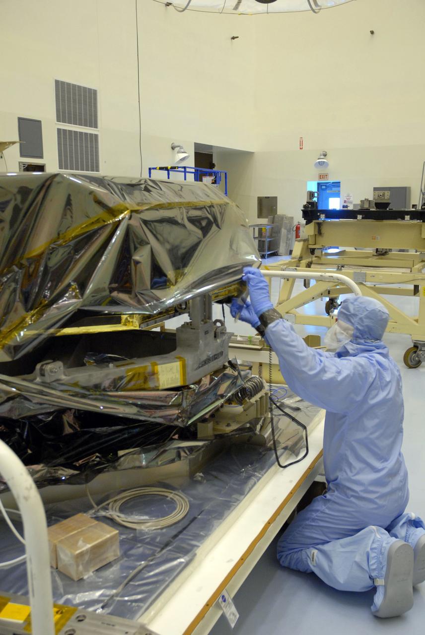 CAPE CANAVERAL, Fla. –  In the Payload Hazardous Servicing Facility at NASA's Kennedy Space Center, workers prepare to remove the protective cover from the Hubble Fine Guidance Sensor, or FGS. The FGS will be integrated onto the Orbital Replacement Unit carrier in the clean room of the facility. The sensor will extend the life of the pointing control system on the Hubble Space Telescope. On the mission, this FGS will replace one of the three sensors that is failing and thus outfit the telescope with two completely healthy units, which are needed.  A third, older FGS aboard the telescope will provide additional target-pointing efficiency and redundancy.  Space shuttle Atlantis is targeted to launch on the STS-125 mission Oct. 8.   Photo credit: NASA/Jack Pfaller