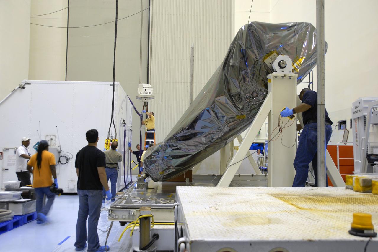 CAPE CANAVERAL, Fla. – In the Payload Hazardous Servicing Facility at NASA's Kennedy Space Center, workers in the background detach the crane from the cover of the shipping container removed from the Multi-Use Lightweight Equipment (MULE) carrier in the foreground. The MULE is part of the payload for the fifth and final shuttle servicing mission to NASA's Hubble Space Telescope, STS-125.  The MULE carrier will join the Flight Support System, the Super Lightweight Interchangeable Carrier and the Orbital Replacement Unit Carrier in the Payload Hazardous Servicing Facility where the Hubble payload is being prepared for launch. The Relative Navigation Sensors and the New Outer Blanket Layers will be on the MULE. The payload is scheduled to go to Launch Pad 39A in mid-September to be installed into Atlantis' payload bay.  Atlantis is targeted to launch Oct. 8 at 1:34 a.m. EDT. .Photo credit: NASA/Amanda Diller