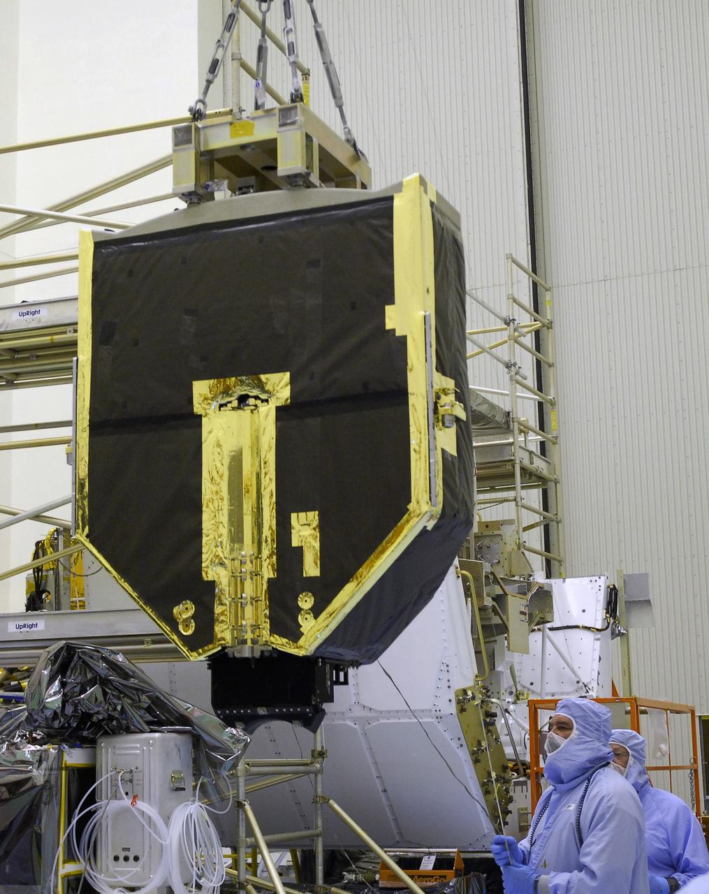 CAPE CANAVERAL, Fla. –   Technicians in the Payload Hazardous Servicing Facility at NASA's Kennedy Space Center help guide the Fine Guidance Sensor, or FGS, as it moves toward the Orbital Replacement Unit Carrier or ORUC, for installation.  An FGS consists of a large structure housing a collection of mirrors, lenses, servos, prisms, beam splitters and photomultiplier tubes. There are three fine guidance sensors on Hubble located at 90-degree intervals around the circumference of the telescope. Along with the gyroscopes, the optical sensors are a key component of Hubble’s highly complex but extraordinarily effective “pointing control system.”  The ORUC is one of three carriers that are being prepared for the integration of telescope science instruments, both internal and external replacement components, as well as the flight support equipment to be used by the astronauts during the fifth and final Hubble servicing mission, STS-125, on space shuttle Atlantis.  Launch is targeted for Oct. 8. Photo credit: NASA/Jim Grossmann