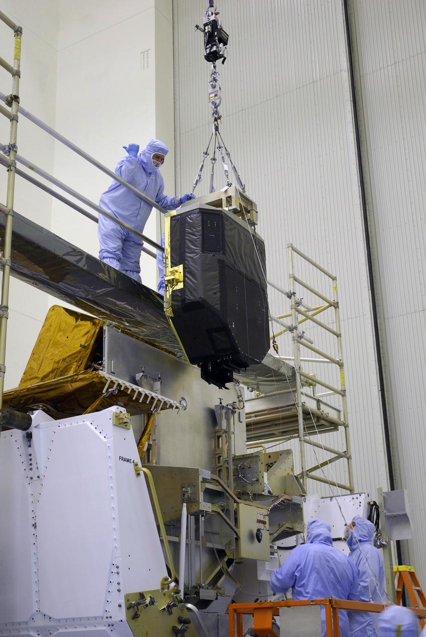 CAPE CANAVERAL, Fla. –  In the Payload Hazardous Servicing Facility at NASA's Kennedy Space Center, the Fine Guidance Sensor, or FGS, is lifted over the crossbar of the stand.  The sensor will be installed on the Orbital Replacement Unit Carrier or ORUC, below.  An FGS consists of a large structure housing a collection of mirrors, lenses, servos, prisms, beam splitters and photomultiplier tubes. There are three fine guidance sensors on Hubble located at 90-degree intervals around the circumference of the telescope. Along with the gyroscopes, the optical sensors are a key component of Hubble’s highly complex but extraordinarily effective “pointing control system.”  The ORUC is one of three carriers that are being prepared for the integration of telescope science instruments, both internal and external replacement components, as well as the flight support equipment to be used by the astronauts during the fifth and final Hubble servicing mission, STS-125, on space shuttle Atlantis.  Launch is targeted for Oct. 8. Photo credit: NASA/Jim Grossmann