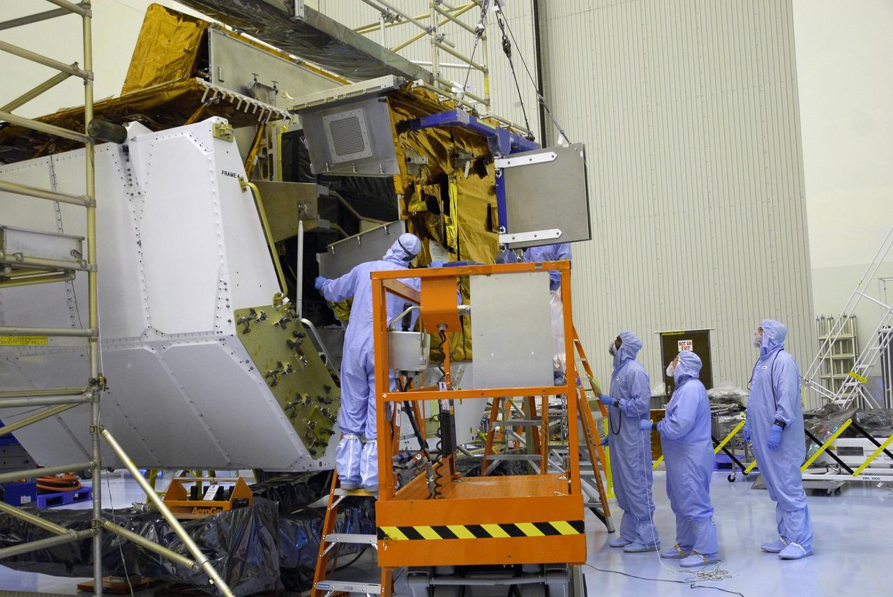 CAPE CANAVERAL, Fla. –  In the Payload Hazardous Servicing Facility at NASA's Kennedy Space Center, workers help guide the Fine Guidance Sensor Scientific Instrument Protective Enclosure, or FSIPE, cover alongside the Orbital Replacement Unit Carrier, or ORUC, for installation. The ORUC is one of three carriers that are being prepared for the integration of telescope science instruments, both internal and external replacement components, as well as the flight support equipment to be used by the astronauts during the fifth and final Hubble servicing mission, STS-125.   Launch is targeted for Oct. 8. PHoto credit: NASA/Jack Pfaller