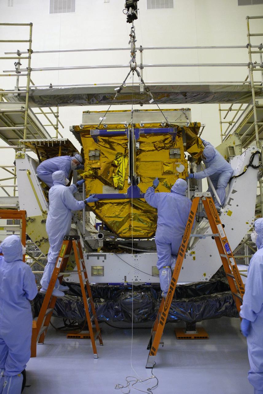 CAPE CANAVERAL, Fla. –   In the Payload Hazardous Servicing Facility at NASA's Kennedy Space Center, workers help maneuver the Fine Guidance Sensor Scientific Instrument Protective Enclosure, or FSIPE, cover into place on the Orbital Replacement Unit Carrier, or ORUC, for installation. The ORUC is one of three carriers that are being prepared for the integration of telescope science instruments, both internal and external replacement components, as well as the flight support equipment to be used by the astronauts during the fifth and final Hubble servicing mission, STS-125.   Launch is targeted for Oct. 8. PHoto credit: NASA/Jack Pfaller