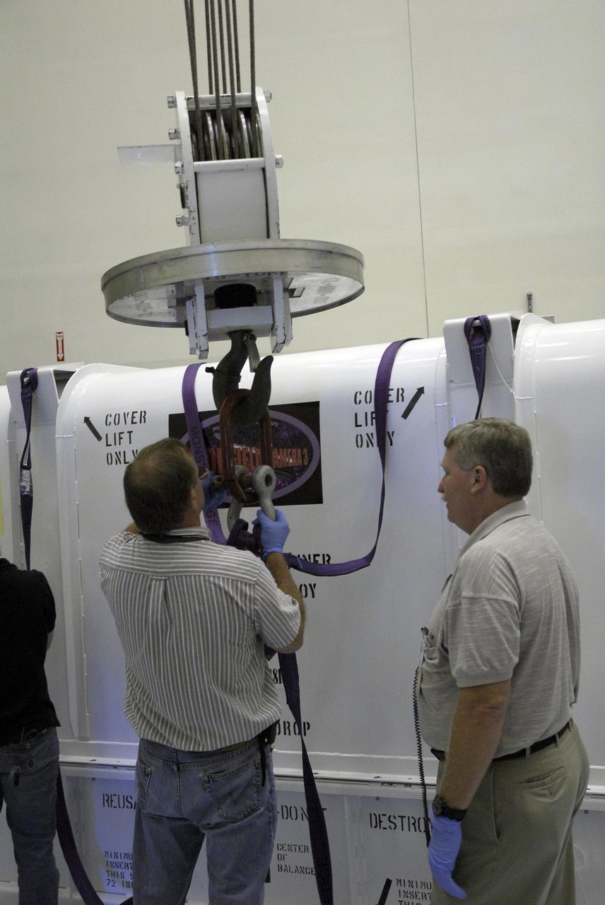 CAPE CANAVERAL, Fla. –  In the Payload Hazardous Servicing Facility at NASA's Kennedy Space Center, technicians attach an overhead crane to the cover of the Wide Field Camera 3, or WFC3, shipping container. As Hubble enters the last stage of its life, WFC3  will be Hubble's next evolutionary step, allowing Hubble to peer ever further into the mysteries of the cosmos. WFC3 will study a diverse range of objects and phenomena, from young and extremely distant galaxies, to much more nearby stellar systems, to objects within our very own solar system.  WFC3 will take the place of Wide Field Planetary Camera 2, which astronauts will bring back to Earth aboard the shuttle. WFC3 is part of the payload on the fifth and final Hubble servicing mission, STS-125, targeted for launch Oct. 8.  Photo credit: NASA/Jack Pfaller