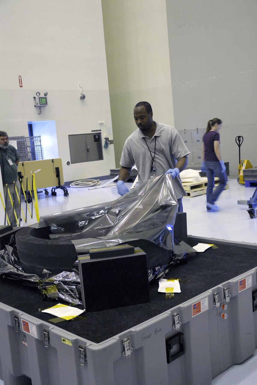 CAPE CANAVERAL, Fla. – In the Payload Hazardous Servicing Facility at NASA's Kennedy Space Center, a technician removes the protective cover from the Soft Capture and Rendezvous System, or SCRS. The SCRS will enable the future rendezvous, capture and safe disposal of Hubble by either a crewed or robotic mission. The SCRS greatly increases the current shuttle capture interfaces on Hubble, therefore significantly reducing the rendezvous and capture design complexities associated with the disposal mission. The SCRS comprises the Soft Capture Mechanism system and the Relative Navigation System and is part of the payload on the fifth and final Hubble servicing mission, STS-125, targeted for launch Oct. 8. Photo credit: NASA/Jack Pfaller