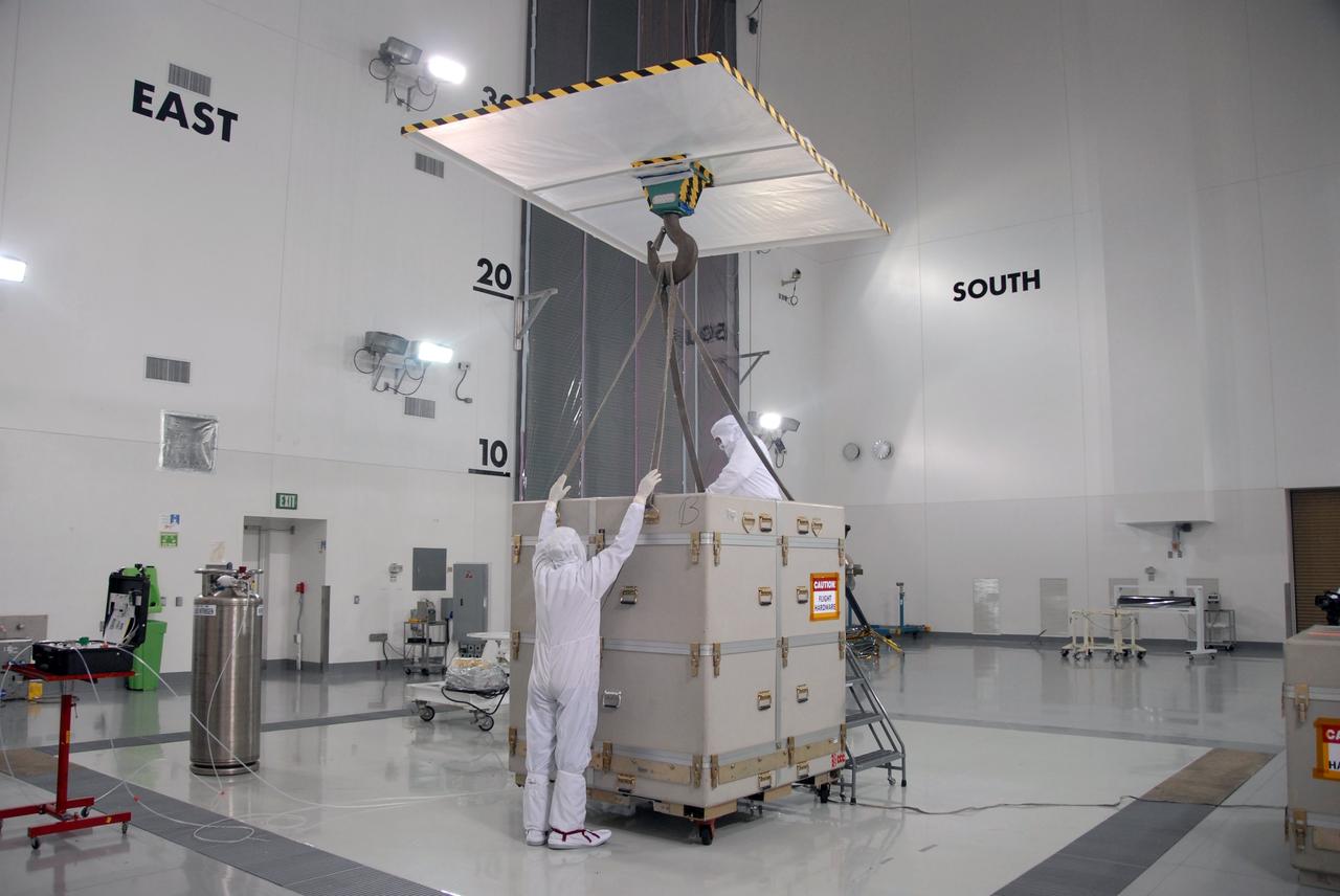 VANDENBERG AIR FORCE BASE, Calif. – At Vandenberg Air Force Base in California, technicians attach an overhead crane to the shipping container cover on NASA's Interstellar Boundary Explorer, or IBEX, mission spacecraft. The IBEX satellite will make the first map of the boundary between the Solar System and interstellar space. IBEX is the first mission designed to detect the edge of the Solar System. As the solar wind from the sun flows out beyond Pluto, it collides with the material between the stars, forming a shock front. IBEX contains two neutral atom imagers designed to detect particles from the termination shock at the boundary between the Solar System and interstellar space. IBEX also will study galactic cosmic rays, energetic particles from beyond the Solar System that pose a health and safety hazard for humans exploring beyond Earth orbit. IBEX will make these observations from a highly elliptical orbit that takes it beyond the interference of the Earth's magnetosphere. IBEX is targeted for launch from the Pegasus XL rocket on Oct. 5. Photo credit: NASA/Mark Mackley