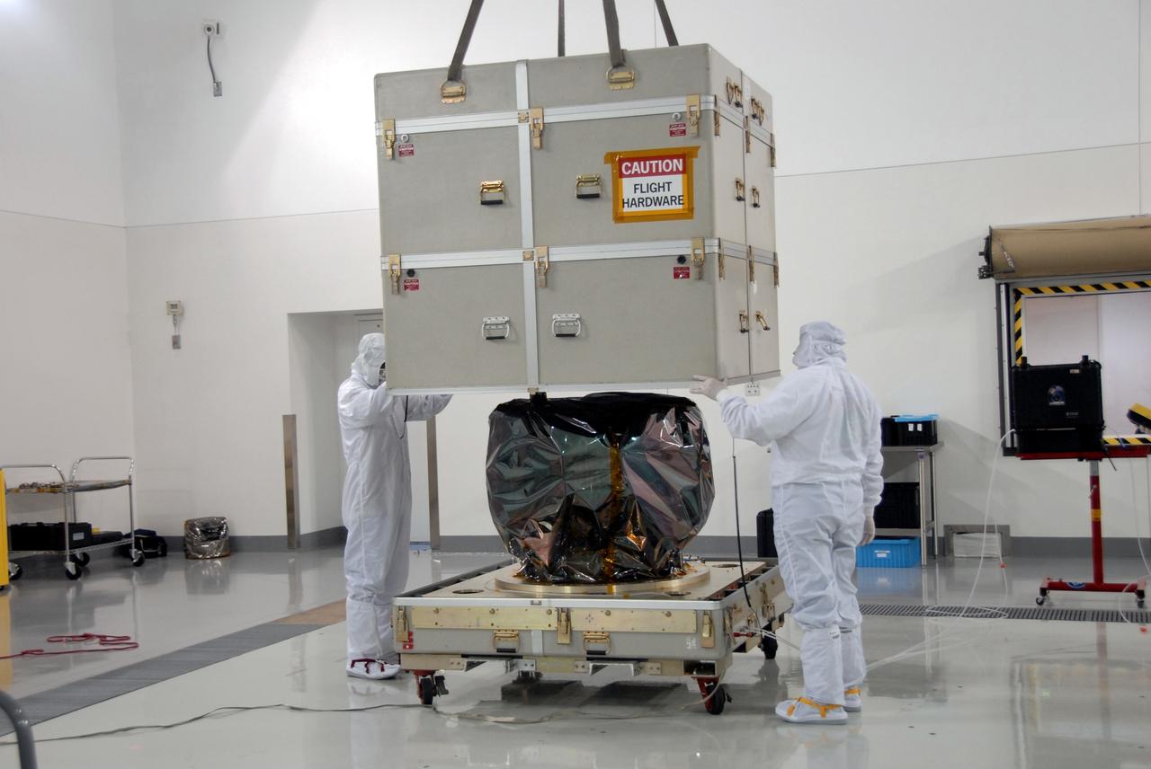 VANDENBERG AIR FORCE BASE, Calif. – At Vandenberg Air Force Base in California, an overhead crane lifts the cover of a shipping container to reveal NASA's Interstellar Boundary Explorer, or IBEX, mission spacecraft. The IBEX satellite will make the first map of the boundary between the Solar System and interstellar space. IBEX is the first mission designed to detect the edge of the Solar System. As the solar wind from the sun flows out beyond Pluto, it collides with the material between the stars, forming a shock front. IBEX contains two neutral atom imagers designed to detect particles from the termination shock at the boundary between the Solar System and interstellar space. IBEX also will study galactic cosmic rays, energetic particles from beyond the Solar System that pose a health and safety hazard for humans exploring beyond Earth orbit. IBEX will make these observations from a highly elliptical orbit that takes it beyond the interference of the Earth's magnetosphere. IBEX is targeted for launch from the Pegasus XL rocket on Oct. 5. Photo credit: NASA/Mark Mackley