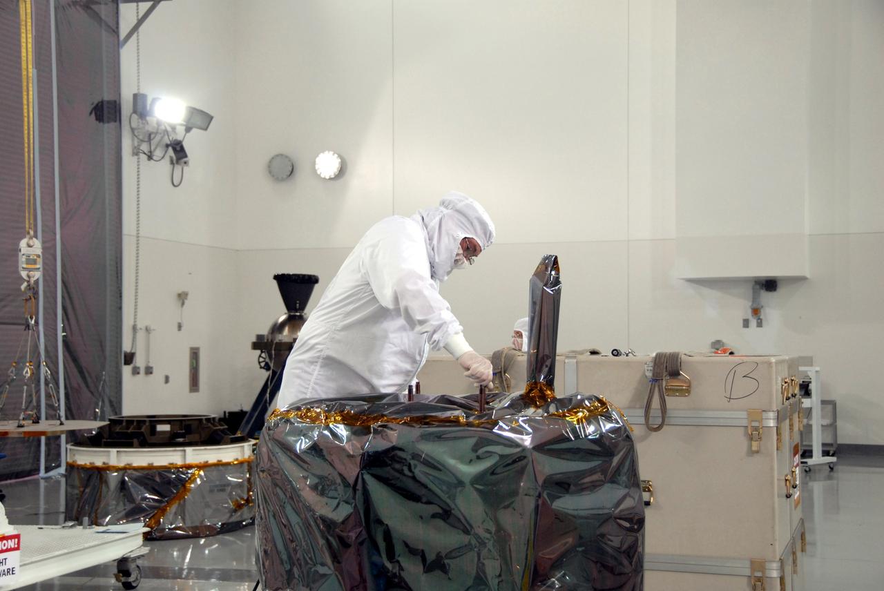 VANDENBERG AIR FORCE BASE, Calif. – At Vandenberg Air Force Base in California, technicians prepare NASA's Interstellar Boundary Explorer, or IBEX, mission spacecraft to be lifted from the shipping platform and moved to a mobile stand in the background. The IBEX satellite will make the first map of the boundary between the Solar System and interstellar space. IBEX is the first mission designed to detect the edge of the Solar System. As the solar wind from the sun flows out beyond Pluto, it collides with the material between the stars, forming a shock front. IBEX contains two neutral atom imagers designed to detect particles from the termination shock at the boundary between the Solar System and interstellar space. IBEX also will study galactic cosmic rays, energetic particles from beyond the Solar System that pose a health and safety hazard for humans exploring beyond Earth orbit. IBEX will make these observations from a highly elliptical orbit that takes it beyond the interference of the Earth's magnetosphere. IBEX is targeted for launch from the Pegasus XL rocket on Oct. 5. Photo credit: NASA/Mark Mackley