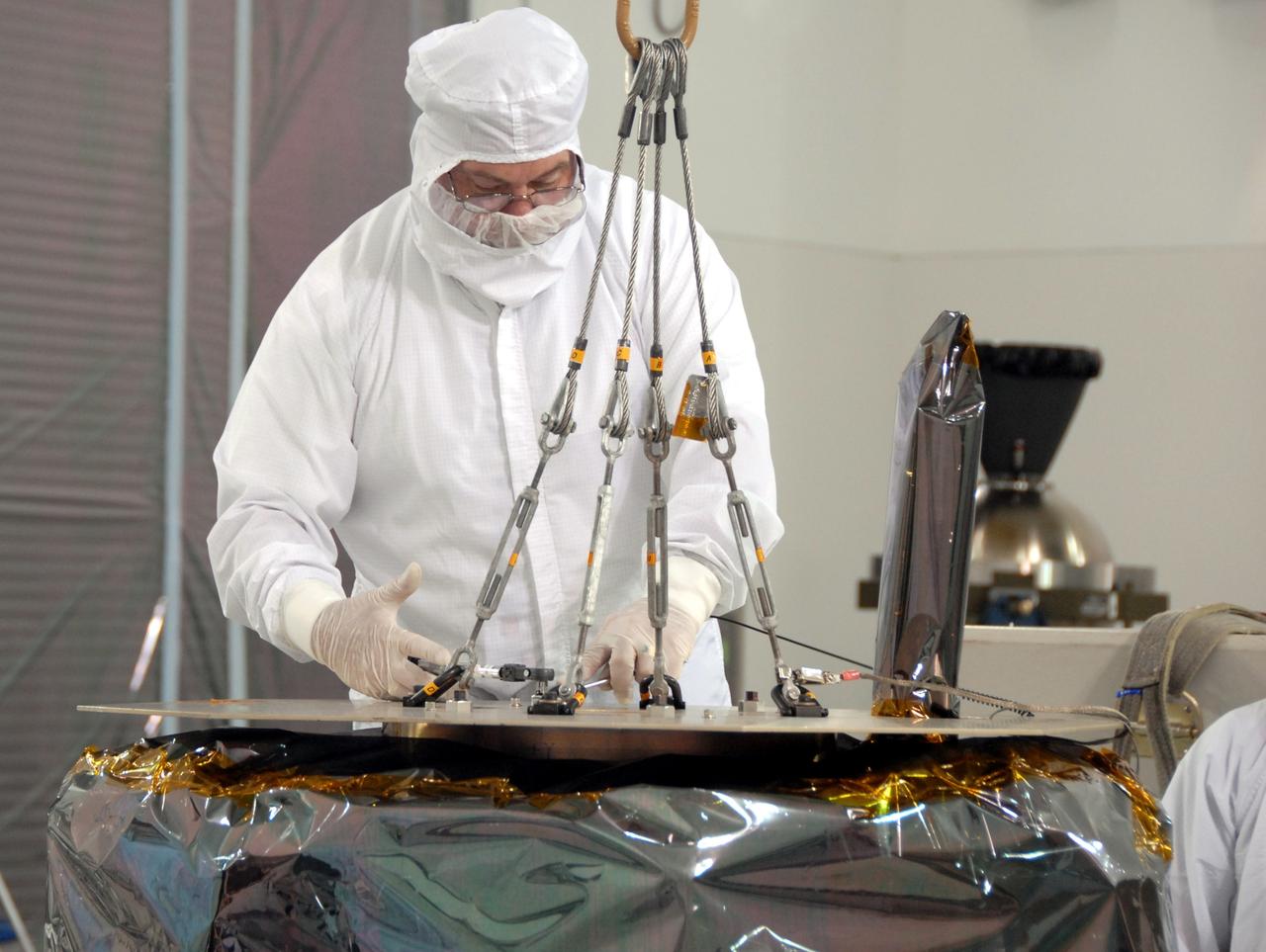 VANDENBERG AIR FORCE BASE, Calif. – At Vandenberg Air Force Base in California, a technician secures the overhead crane that will lift NASA's Interstellar Boundary Explorer, or IBEX, mission spacecraft and move it to a nearby mobile stand. The IBEX satellite will make the first map of the boundary between the Solar System and interstellar space. IBEX is the first mission designed to detect the edge of the Solar System. As the solar wind from the sun flows out beyond Pluto, it collides with the material between the stars, forming a shock front. IBEX contains two neutral atom imagers designed to detect particles from the termination shock at the boundary between the Solar System and interstellar space. IBEX also will study galactic cosmic rays, energetic particles from beyond the Solar System that pose a health and safety hazard for humans exploring beyond Earth orbit. IBEX will make these observations from a highly elliptical orbit that takes it beyond the interference of the Earth's magnetosphere. IBEX is targeted for launch from the Pegasus XL rocket on Oct. 5. Photo credit: NASA