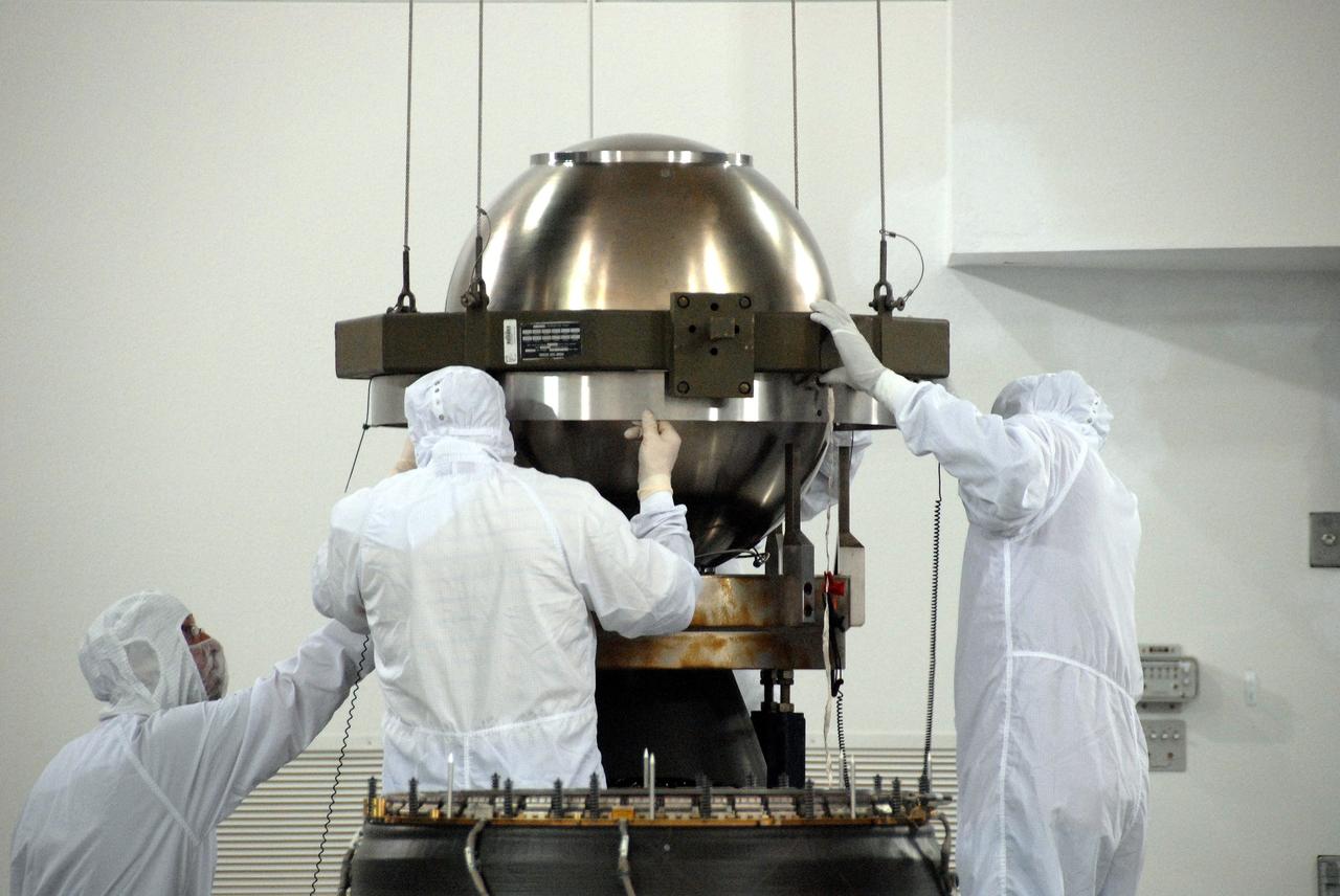 VANDENBERG AIR FORCE BASE, Calif. – At Vandenberg Air Force Base in California, technicians help guide the Star-27 kick motor and nozzle for NASA's Interstellar Boundary Explorer, or IBEX, mission spacecraft. The motor/nozzle will be inserted in the adapter cone (bottom of the foreground). The IBEX satellite will make the first map of the boundary between the Solar System and interstellar space. IBEX is the first mission designed to detect the edge of the Solar System. As the solar wind from the sun flows out beyond Pluto, it collides with the material between the stars, forming a shock front. IBEX contains two neutral atom imagers designed to detect particles from the termination shock at the boundary between the Solar System and interstellar space. IBEX also will study galactic cosmic rays, energetic particles from beyond the Solar System that pose a health and safety hazard for humans exploring beyond Earth orbit. IBEX will make these observations from a highly elliptical orbit that takes it beyond the interference of the Earth's magnetosphere. IBEX is targeted for launch from the Pegasus XL rocket on Oct. 5. Photo credit: NASA/R. Bledsoe