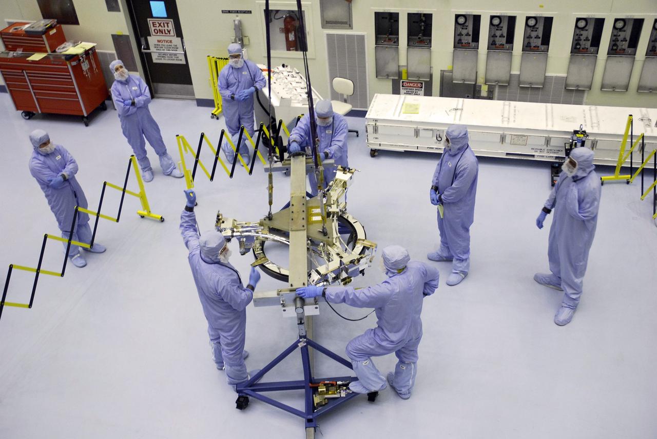 CAPE CANAVERAL, Fla. – In the Payload Hazardous Servicing Facility at NASA's Kennedy Space Center, a technician signals to begin lifting the Soft Capture Mechanism (SCM), part of the Soft Capture and Rendezvous System, or SCRS. The SCM will be transferred to the stand holding the Flight Support System, or FSS, carrier where the SCM will be mated to the FSS. The SCRS will enable the future rendezvous, capture and safe disposal of NASA's Hubble Space Telescope by either a crewed or robotic mission. The ring-like device attaches to Hubble’s aft bulkhead. The SCRS greatly increases the current shuttle capture interfaces on Hubble, therefore significantly reducing the rendezvous and capture design complexities associated with the disposal mission. The FSS will join the Multi-Use Lightweight Equipment, or MULE, carrier, the Super Lightweight Interchangeable Carrier and the Orbital Replacement Unit Carrier as payload on space shuttle Atlantis's STS-125 mission. The payload is scheduled to go to Launch Pad 39A in mid-September to be installed into Atlantis' payload bay. Atlantis is targeted to launch Oct. 8 at 1:34 a.m. EDT. Photo credit: NASA/Troy Cryder