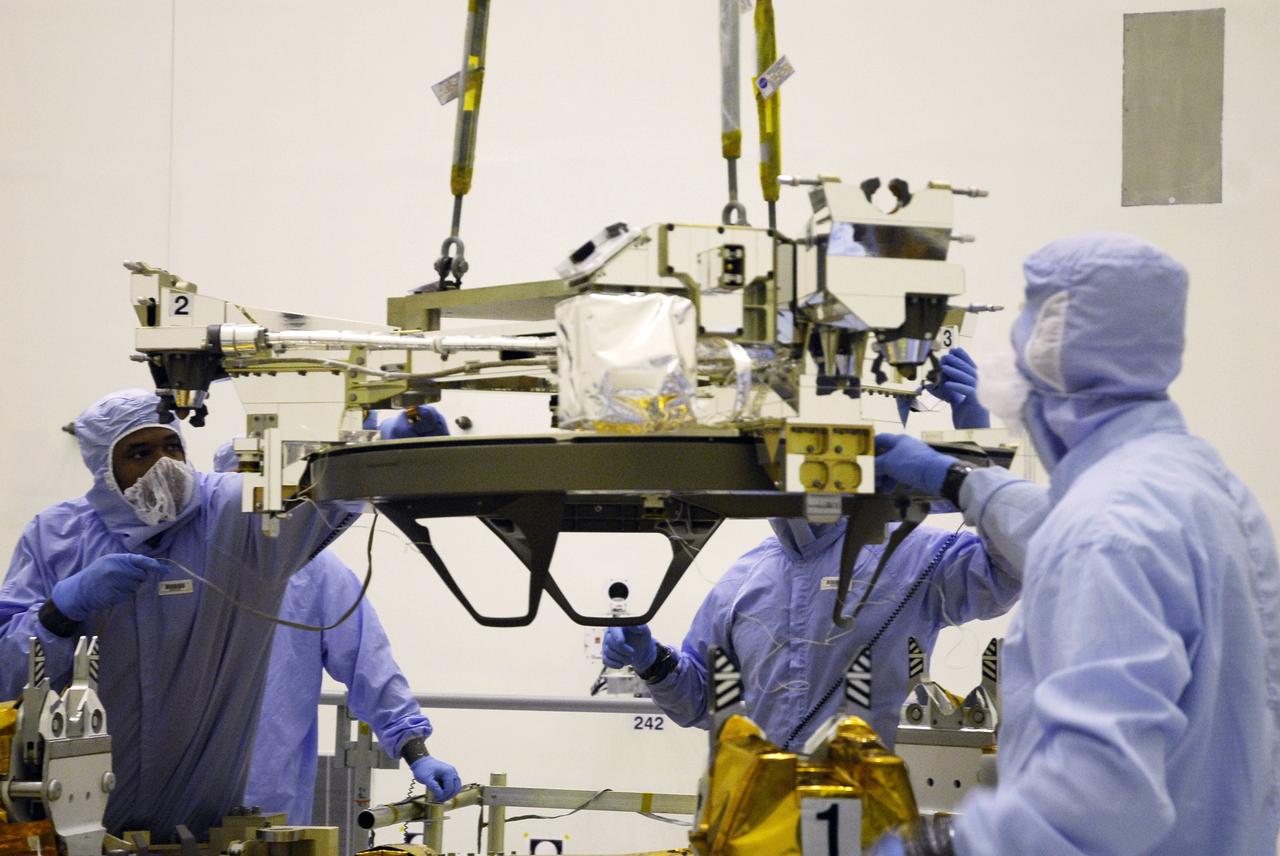 CAPE CANAVERAL, Fla. – In the Payload Hazardous Servicing Facility at NASA's Kennedy Space Center, an overhead crane lowers the Soft Capture Mechanism (SCM), part of the Soft Capture and Rendezvous System, or SCRS, closer to the Flight Support System, or FSS, carrier. The SCRS will enable the future rendezvous, capture and safe disposal of NASA's Hubble Space Telescope by either a crewed or robotic mission. The ring-like device attaches to Hubble’s aft bulkhead. The SCRS greatly increases the current shuttle capture interfaces on Hubble, therefore significantly reducing the rendezvous and capture design complexities associated with the disposal mission. The FSS will join the Multi-Use Lightweight Equipment, or MULE, carrier, the Super Lightweight Interchangeable Carrier and the Orbital Replacement Unit Carrier as payload on space shuttle Atlantis's STS-125 mission. The payload is scheduled to go to Launch Pad 39A in mid-September to be installed into Atlantis' payload bay. Atlantis is targeted to launch Oct. 8 at 1:34 a.m. EDT. Photo credit: NASA/Troy Cryder