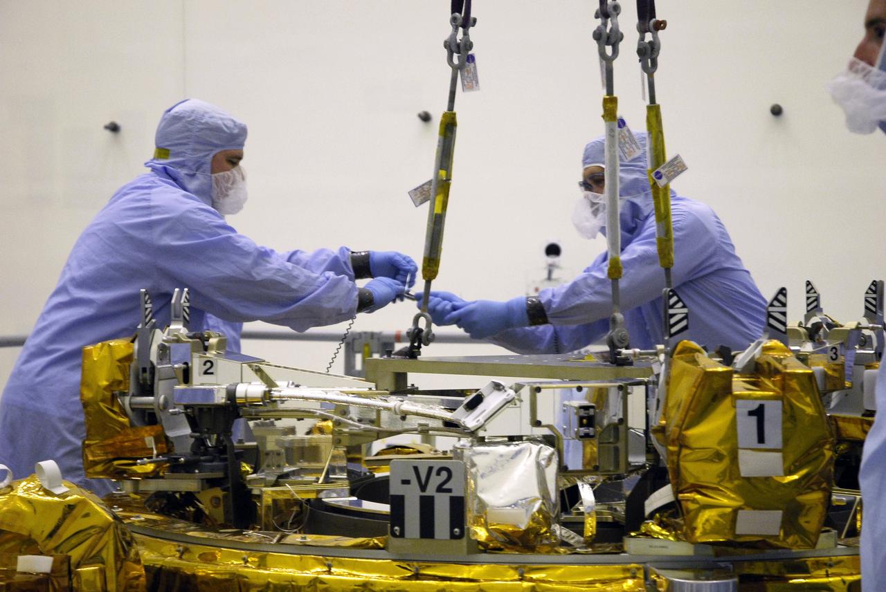 CAPE CANAVERAL, Fla. – In the Payload Hazardous Servicing Facility at NASA's Kennedy Space Center, technicians begin removing the cables from the crane holding the Soft Capture Mechanism (SCM), part of the Soft Capture and Rendezvous System, or SCRS. The SCM rests on the Flight Support System, or FSS,carrier and will be mated to the carrier. The SCRS will enable the future rendezvous, capture and safe disposal of NASA's Hubble Space Telescope by either a crewed or robotic mission. The ring-like device attaches to Hubble’s aft bulkhead. The SCRS greatly increases the current shuttle capture interfaces on Hubble, therefore significantly reducing the rendezvous and capture design complexities associated with the disposal mission. The FSS will join the Multi-Use Lightweight Equipment, or MULE, carrier, the Super Lightweight Interchangeable Carrier and the Orbital Replacement Unit Carrier as payload on space shuttle Atlantis's STS-125 mission. The payload is scheduled to go to Launch Pad 39A in mid-September to be installed into Atlantis' payload bay. Atlantis is targeted to launch Oct. 8 at 1:34 a.m. EDT. Photo credit: NASA/Troy Cryder