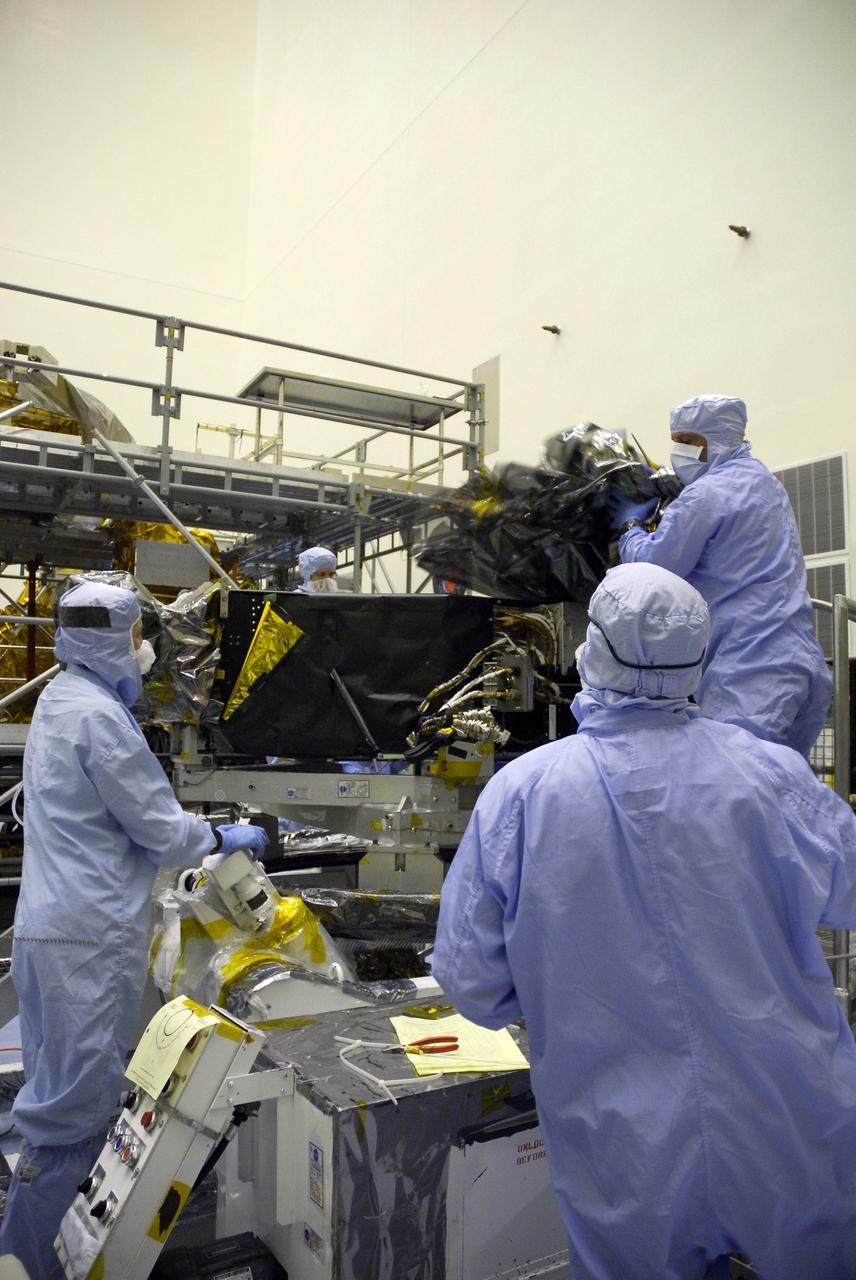 CAPE CANAVERAL, Fla. –    Technicians in the Payload Hazardous Servicing Facility begin removing the protective cover from the Wide Field Camera 3, or WFC3.  The WFC3 is part of the payload on space shuttle Atlantis for the fifth and final Hubble servicing mission, STS-125.   As Hubble enters the last stage of its life, WFC3 will be Hubble's next evolutionary step, allowing Hubble to peer ever further into the mysteries of the cosmos. WFC3 will study a diverse range of objects and phenomena, from young and extremely distant galaxies, to much more nearby stellar systems, to objects within our very own solar system. WFC3 will take the place of Wide Field Planetary Camera 2, which astronauts will bring back to Earth aboard the shuttle. Launch of Atlantis is targeted at 1:34 a.m. EDT Oct. 8.  Photo credit: NASA/Jack Pfaller
