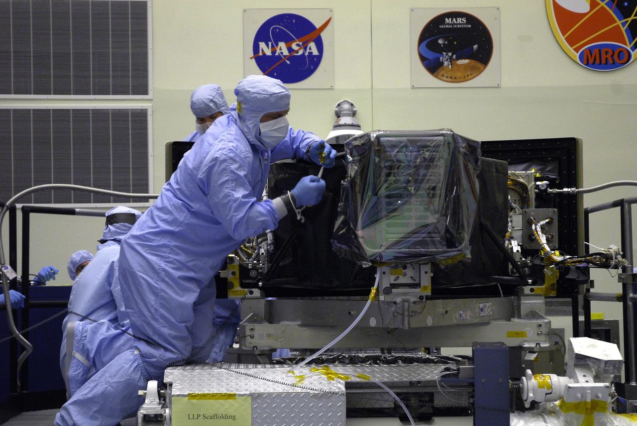 CAPE CANAVERAL, Fla. –   Technicians in the Payload Hazardous Servicing Facility remove the protective cover from the Wide Field Camera 3, or WFC3.  The WFC3 is part of the payload on space shuttle Atlantis for the fifth and final Hubble servicing mission, STS-125.  As Hubble enters the last stage of its life, WFC3 will be Hubble's next evolutionary step, allowing Hubble to peer ever further into the mysteries of the cosmos. WFC3 will study a diverse range of objects and phenomena, from young and extremely distant galaxies, to much more nearby stellar systems, to objects within our very own solar system. WFC3 will take the place of Wide Field Planetary Camera 2, which astronauts will bring back to Earth aboard the shuttle. Launch of Atlantis is targeted at 1:34 a.m. EDT Oct. 8.  Photo credit: NASA/Jack Pfaller