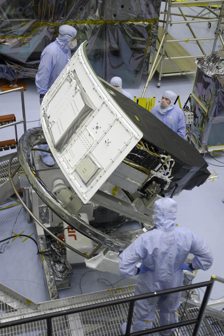 CAPE CANAVERAL, Fla. –  In the Payload Hazardous Servicing Facility at NASA's Kennedy Space Center, technicians stand by as the Wide Field Camera 3, or WFC3, is rotated.  The WFC3 will be transferred to the Super Lightweight Interchangeable Carrier.  WFC3 is part of the payload on space shuttle Atlantis' STS-125 mission for the fifth and final Hubble servicing flight to NASA's Hubble Space Telescope. The curved edge shown at left is the radiator, the "outside" of WFC3 that will be exposed to space and will expel heat out of Hubble and into space through black body radiation.  As Hubble enters the last stage of its life, WFC3 will be Hubble's next evolutionary step, allowing Hubble to peer ever further into the mysteries of the cosmos. WFC3 will study a diverse range of objects and phenomena, from young and extremely distant galaxies, to much more nearby stellar systems, to objects within our very own solar system. WFC3 will take the place of Wide Field Planetary Camera 2, which astronauts will bring back to Earth aboard the shuttle. Launch of Atlantis is targeted at 1:34 a.m. EDT Oct. 8.  Photo credit: NASA/Amanda Diller