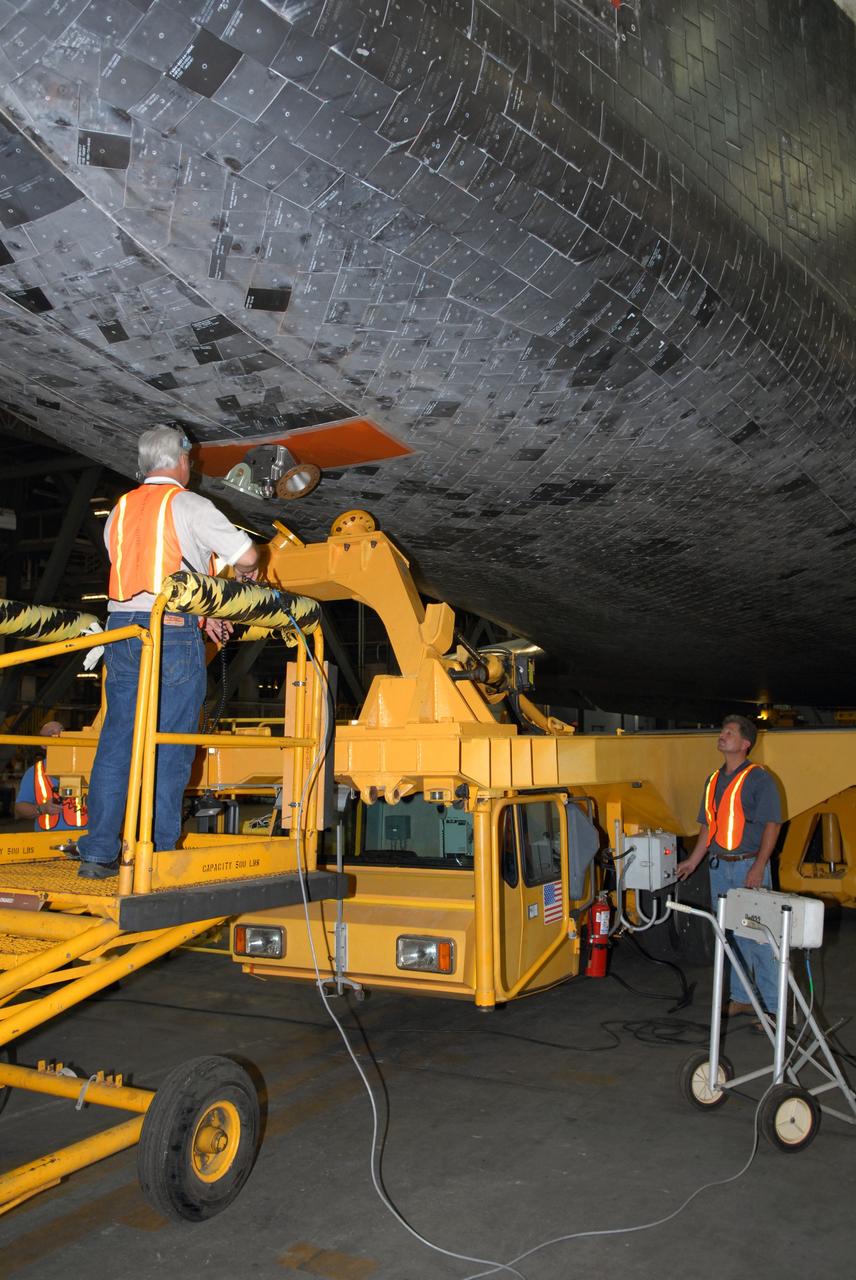 CAPE CANAVERAL, Fla. –   In the Vehicle Assembly Building transfer aisle at NASA's Kennedy Space Center, workers have detached space shuttle Atlantis from its transporter.  An overhead crane will lift Atlantis to vertical for transfer to high bay 3 to be stacked with its external fuel tank and twin solid rocket boosters.  After additional preparations are made, the shuttle will be rolled out to Launch Pad 39A to prepare for launch on the STS-125 mission targeted for Oct. 8.   Photo credit: NASA/Jack Pfaller
