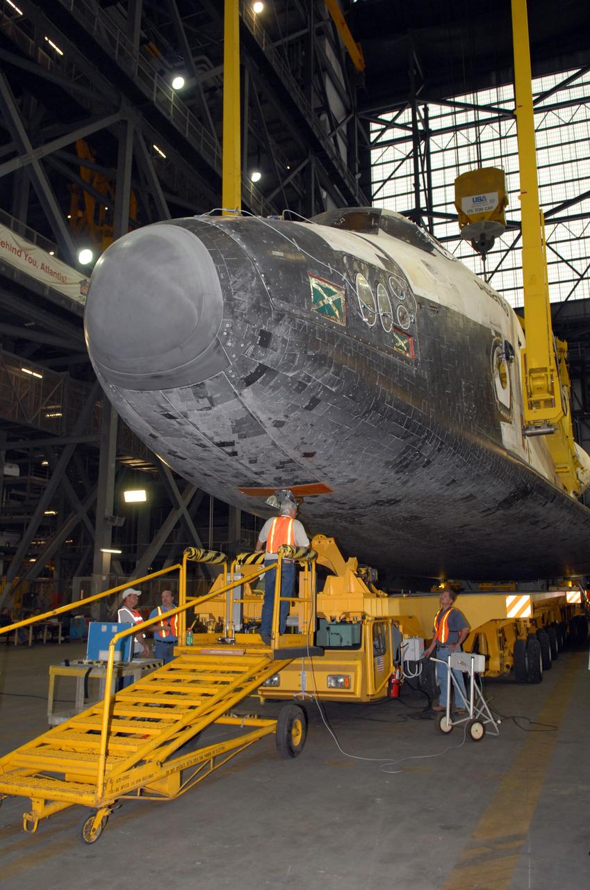 CAPE CANAVERAL, Fla. – In the Vehicle Assembly Building transfer aisle at NASA's Kennedy Space Center, an overhead crane attached to space shuttle Atlantis lifts the shuttle from its transporter. Atlantis will be lifted to vertical for transfer to high bay 3 to be stacked with its external fuel tank and twin solid rocket boosters. After additional preparations are made, the shuttle will be rolled out to Launch Pad 39A to prepare for launch on the STS-125 mission targeted for Oct. 8. Photo credit: NASA/Jack Pfaller
