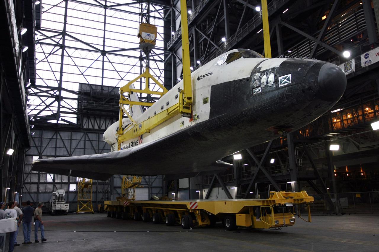 CAPE CANAVERAL, Fla. – In the Vehicle Assembly Building transfer aisle at NASA's Kennedy Space Center, the overhead crane lifts space shuttle Atlantis from its transporter. Atlantis will be raised to vertical for transfer to high bay 3. There it will be stacked with its external fuel tank and twin solid rocket boosters. After additional preparations are made, the shuttle will be rolled out to Launch Pad 39A to prepare for launch on the STS-125 mission targeted for 1:34 a.m. EDT Oct. 8. Photo credit: NASA/Dimitri Gerondidakis