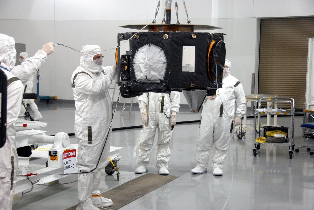 VANDENBERG AIR FORCE BASE, Calif. - At Vandenberg Air Force Base in California, a technician checks NASA's Interstellar Boundary Explorer, or IBEX, spacecraft suspended by an overhead crane. IBEX is undergoing spin balance testing. The IBEX satellite will make the first map of the boundary between the Solar System and interstellar space. IBEX is the first mission designed to detect the edge of the Solar System. As the solar wind from the sun flows out beyond Pluto, it collides with the material between the stars, forming a shock front. IBEX contains two neutral atom imagers designed to detect particles from the termination shock at the boundary between the Solar System and interstellar space. IBEX also will study galactic cosmic rays, energetic particles from beyond the Solar System that pose a health and safety hazard for humans exploring beyond Earth orbit. IBEX will make these observations from a highly elliptical orbit that takes it beyond the interference of the Earth's magnetosphere. IBEX is targeted for launch from a Pegasus XL rocket on Oct. 5. Photo credit: NASA/VAFB