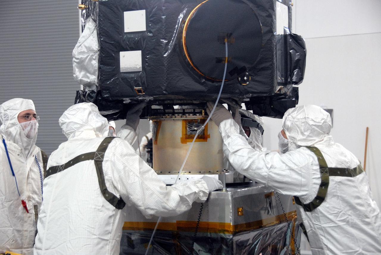 VANDENBERG AIR FORCE BASE, Calif. - At Vandenberg Air Force Base in California, technicians help place NASA's Interstellar Boundary Explorer, or IBEX, spacecraft onto a stand for spin balance testing. The IBEX satellite will make the first map of the boundary between the Solar System and interstellar space. IBEX is the first mission designed to detect the edge of the Solar System. As the solar wind from the sun flows out beyond Pluto, it collides with the material between the stars, forming a shock front. IBEX contains two neutral atom imagers designed to detect particles from the termination shock at the boundary between the Solar System and interstellar space. IBEX also will study galactic cosmic rays, energetic particles from beyond the Solar System that pose a health and safety hazard for humans exploring beyond Earth orbit. IBEX will make these observations from a highly elliptical orbit that takes it beyond the interference of the Earth's magnetosphere. IBEX is targeted for launch from a Pegasus XL rocket on Oct. 5. Photo credit: NASA/VAFB