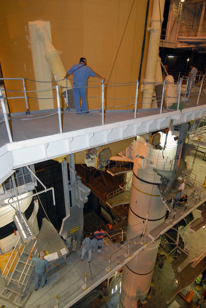 CAPE CANAVERAL, Fla. –   – In the Vehicle Assembly Building at NASA's Kennedy Space Center, workers keep watch as external fuel tank 129 is lowered into high bay 1 where it will be mated with the solid rocket boosters on the mobile launcher platform. The external tank-SRB stack will be mated in two weeks to space shuttle Endeavour for the STS-126 mission.  The STS-126 mission will deliver a Multi-Purpose Logistics Module to the International Space Station.  Launch is targeted for Nov. 10. Photo credit: NASA/Jack Pfaller