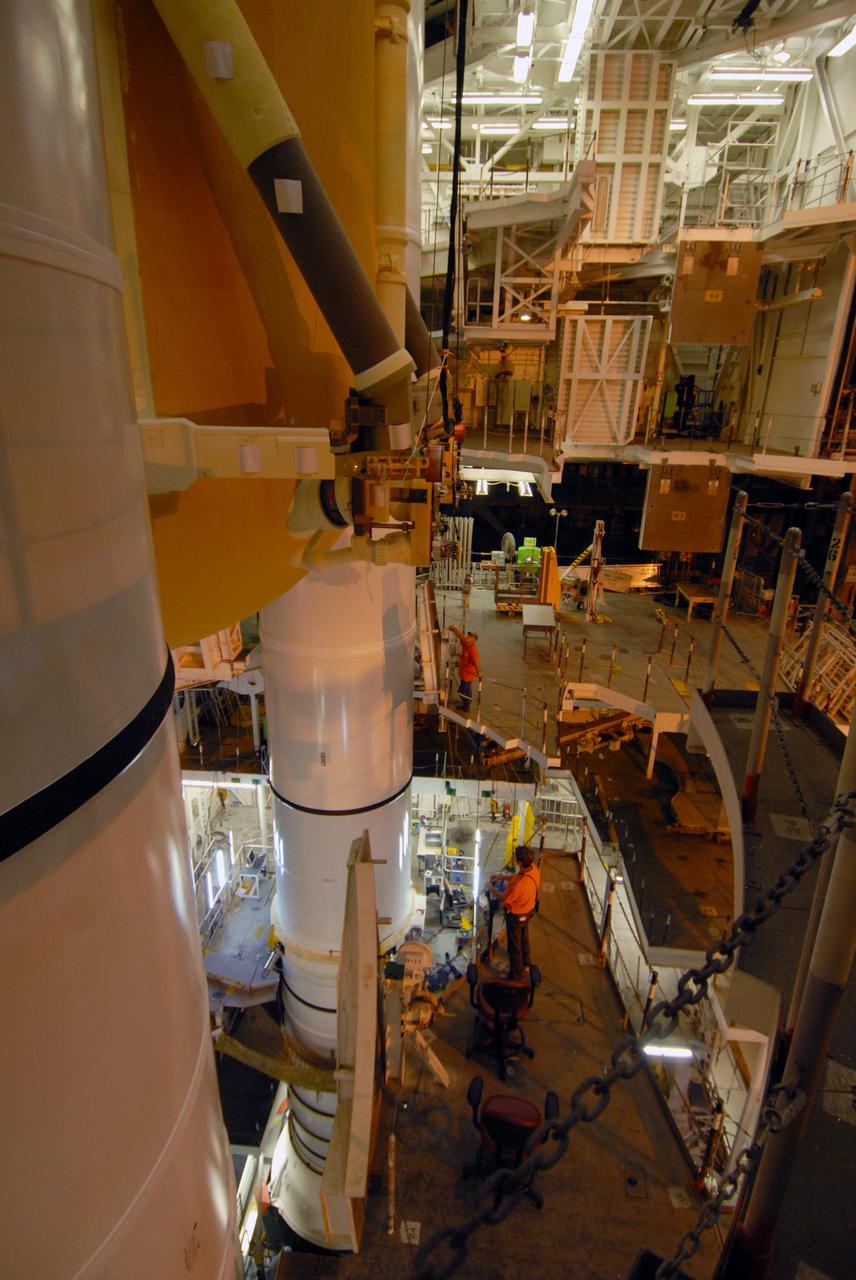 CAPE CANAVERAL, Fla. –   In the Vehicle Assembly Building at NASA's Kennedy Space Center, external fuel tank 129 is lowered into high bay 1 between the solid rocket boosters at left for mating on the mobile launcher platform. The external tank-SRB stack will then be mated in two weeks to space shuttle Endeavour for the STS-126 mission.  The STS-126 mission will deliver a Multi-Purpose Logistics Module to the International Space Station.  Launch is targeted for Nov. 10. Photo credit: NASA/Jack Pfaller