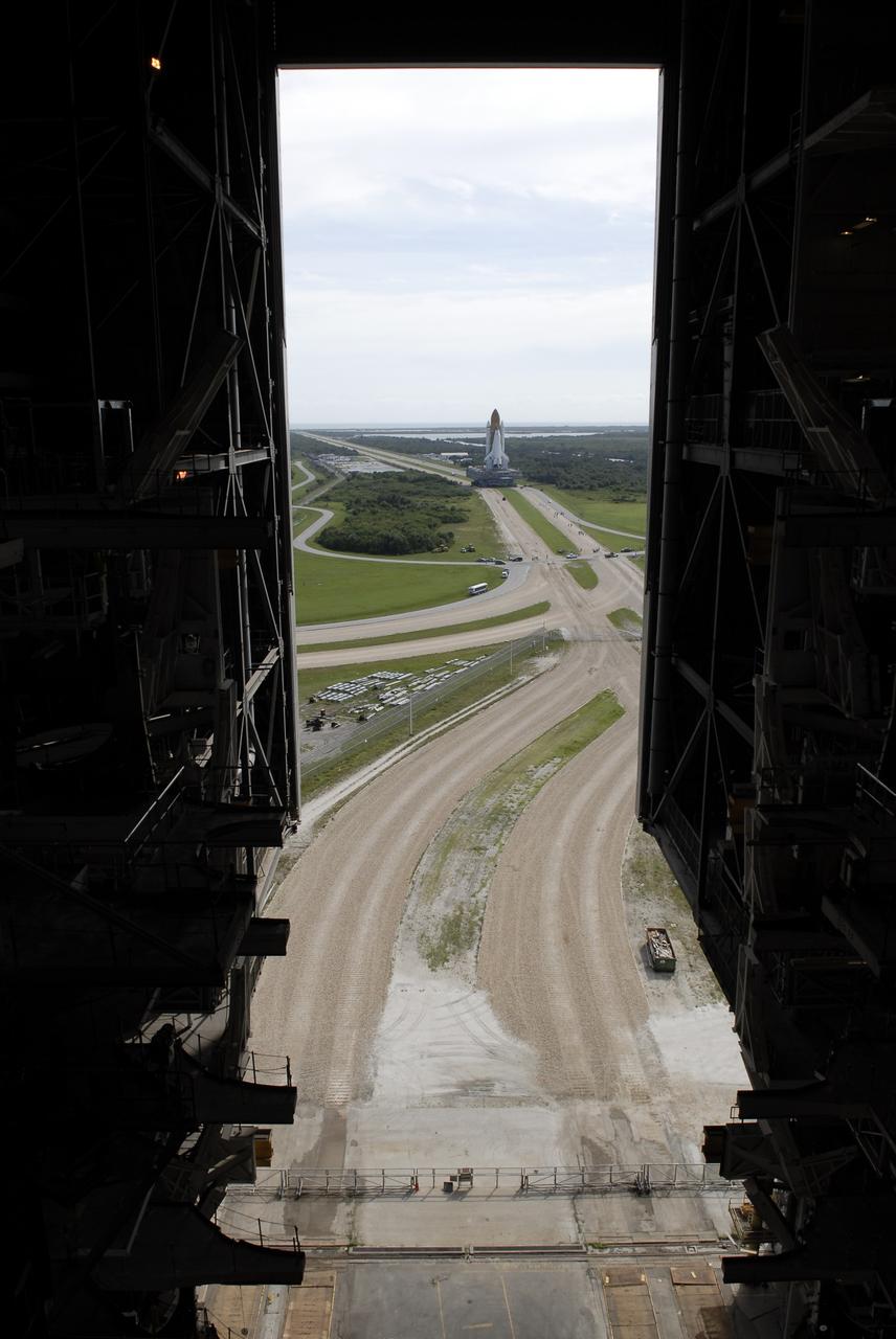 CAPE CANAVERAL, Fla. –   The crawlerway stretches toward the horizon as viewed from inside the Vehicle Assembly Building at NASA’s Kennedy Space Center.  Space shuttle Atlantis nears the bend in the crawlerway to take it to  Launch Pad 39A.  The shuttle stack, with solid rocket boosters and external fuel tank attached to Atlantis, rest on the mobile launcher platform.  Movement is provided by the crawler-transporter underneath.  First motion occurred at 9:19 a.m. EDT. The Sept. 2 rollout date was postponed due to Tropical Storm Hanna’s shift to a northern track. Atlantis is scheduled to launch on the STS-125 mission to service NASA’s Hubble Space Telescope.  Launch is targeted for Oct. 8.  Photo credit: NASA/Kim Shiflett